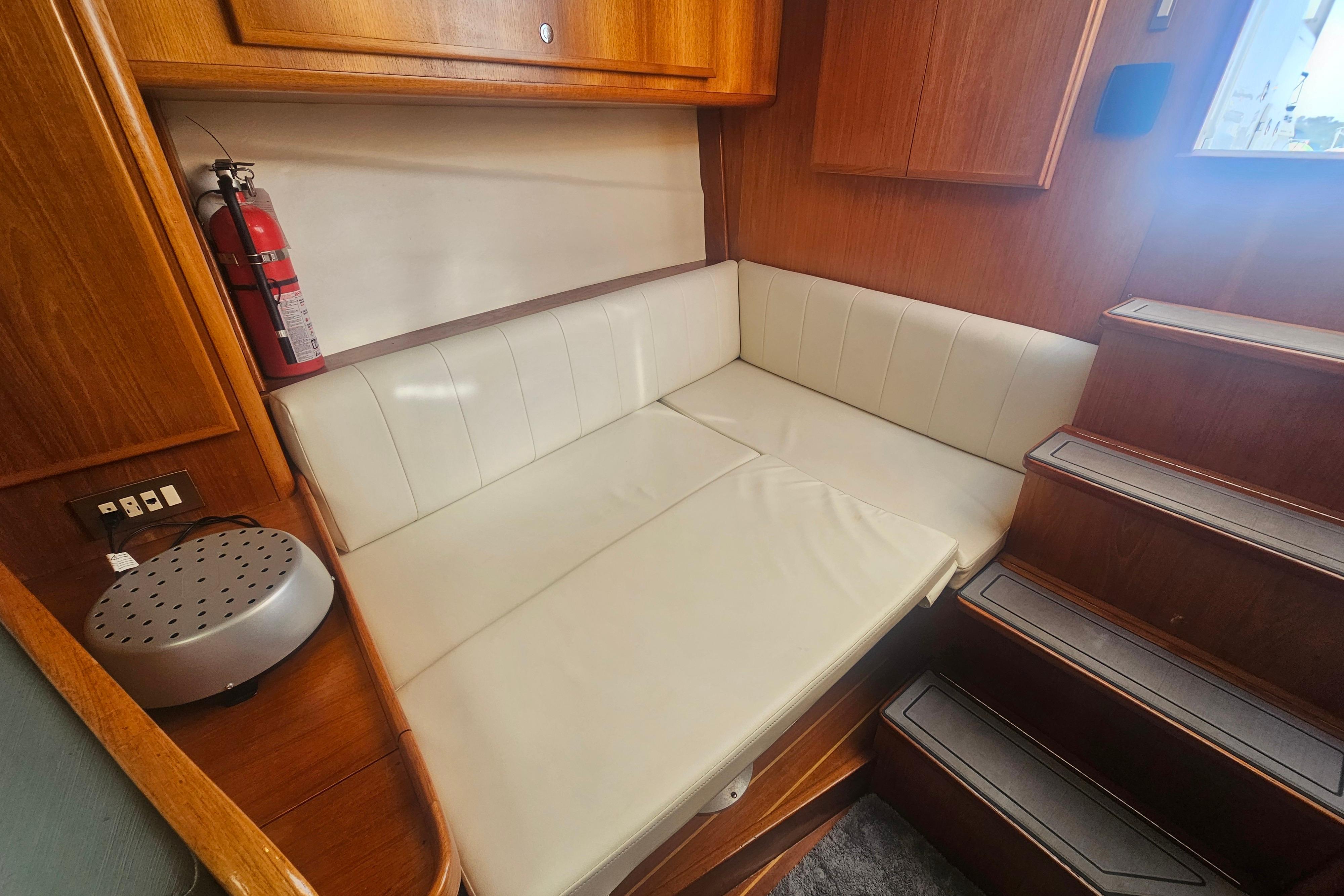 2003 Topaz 32 Express cabin interior with white seating and wooden accents.