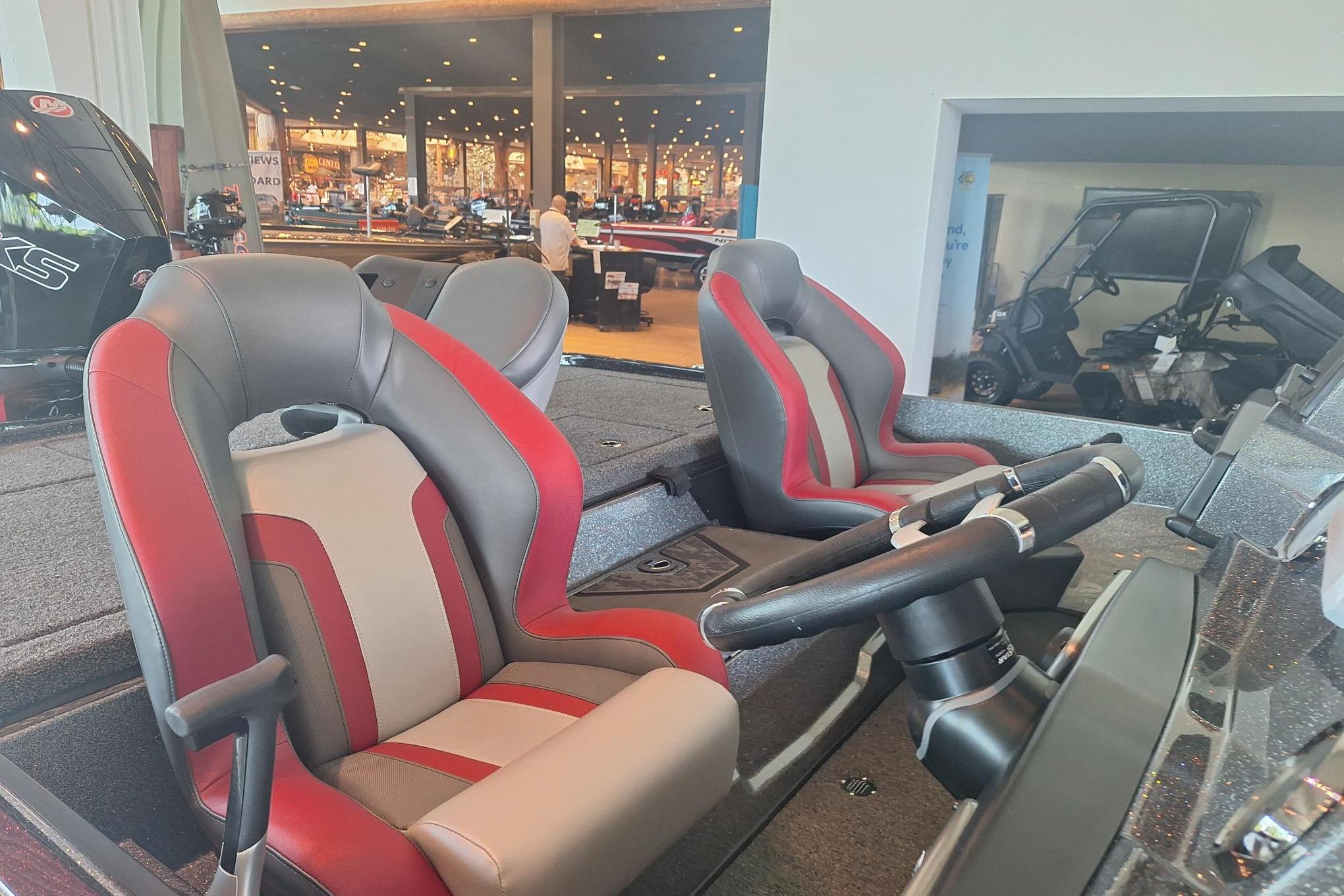 2026 Nitro Z20 XL boat interior with red and gray seats, steering wheel visible.