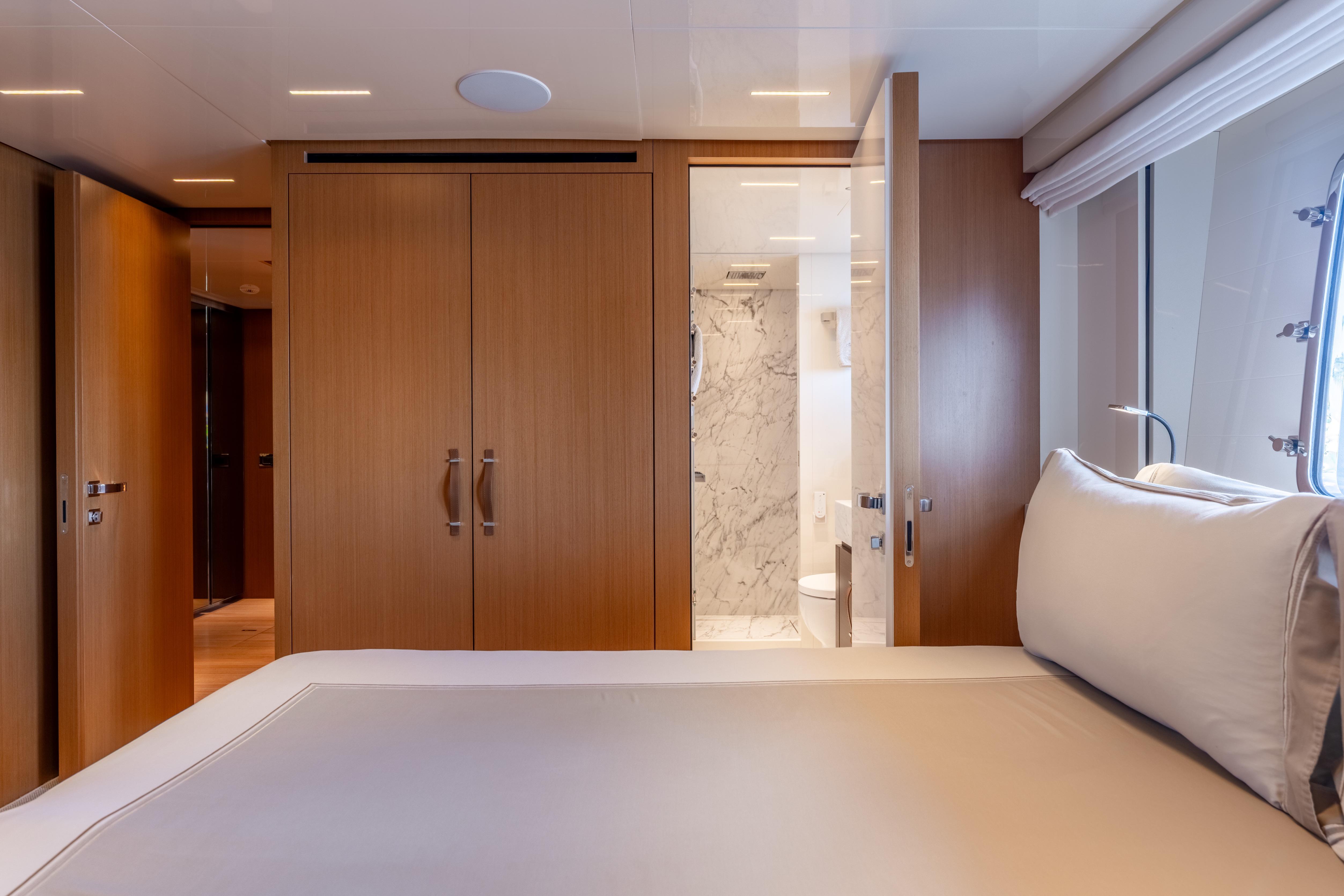 Luxurious 2023 Sanlorenzo SL120A yacht bedroom with ensuite bathroom and elegant wood finishes.