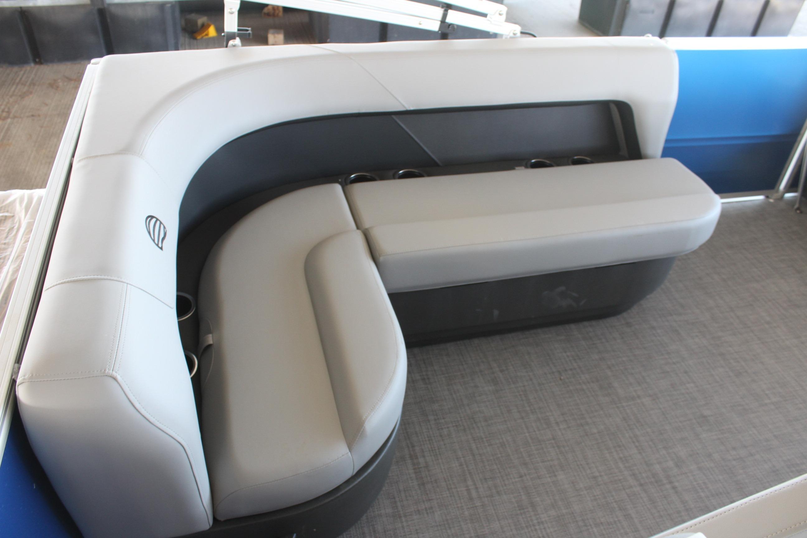 2026 Sun Tracker Party Barge 16 DLX interior seating with gray upholstery and cup holders.
