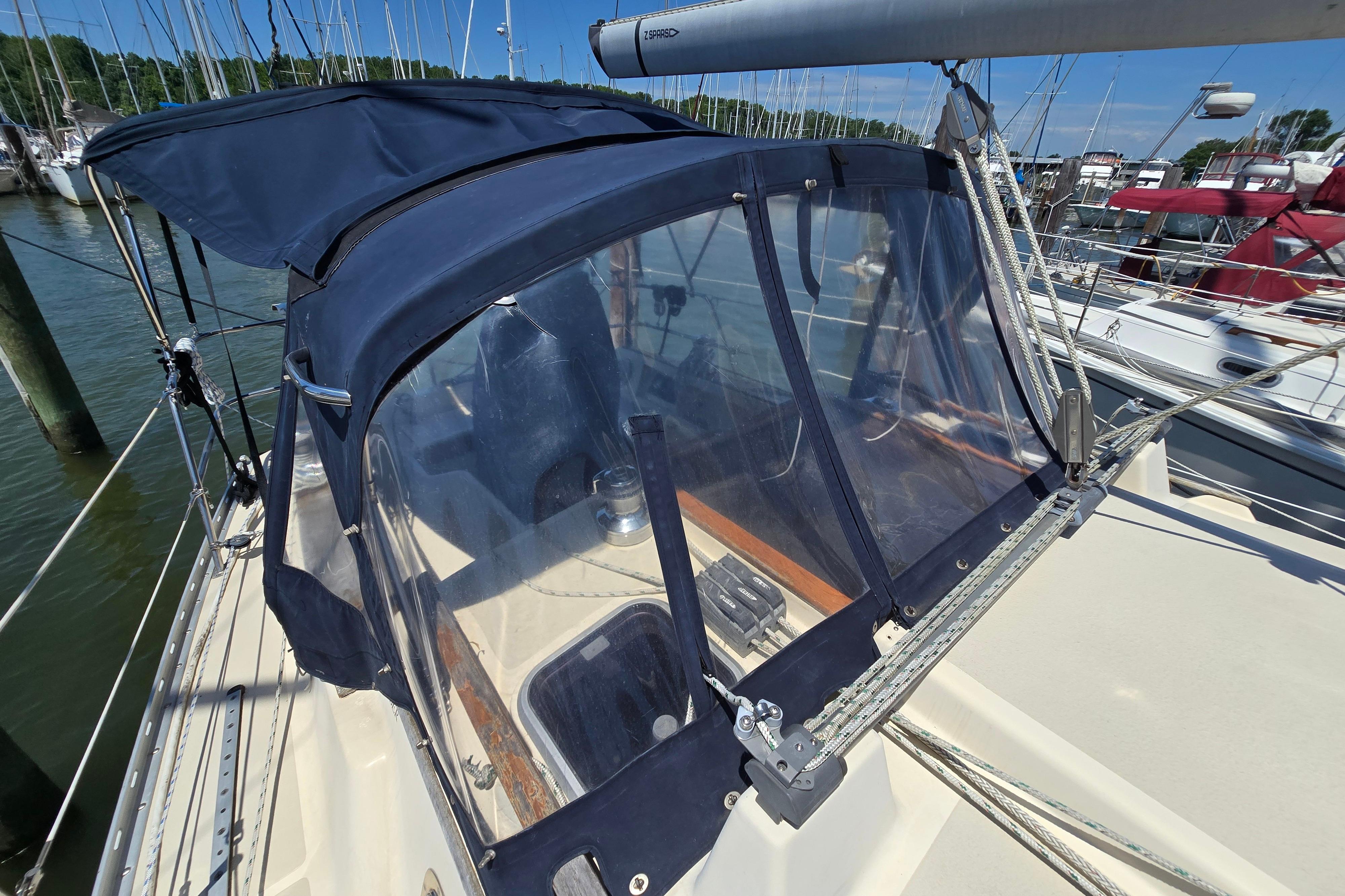 1993 Caliber 35 sailboat with blue canvas cover docked at marina.