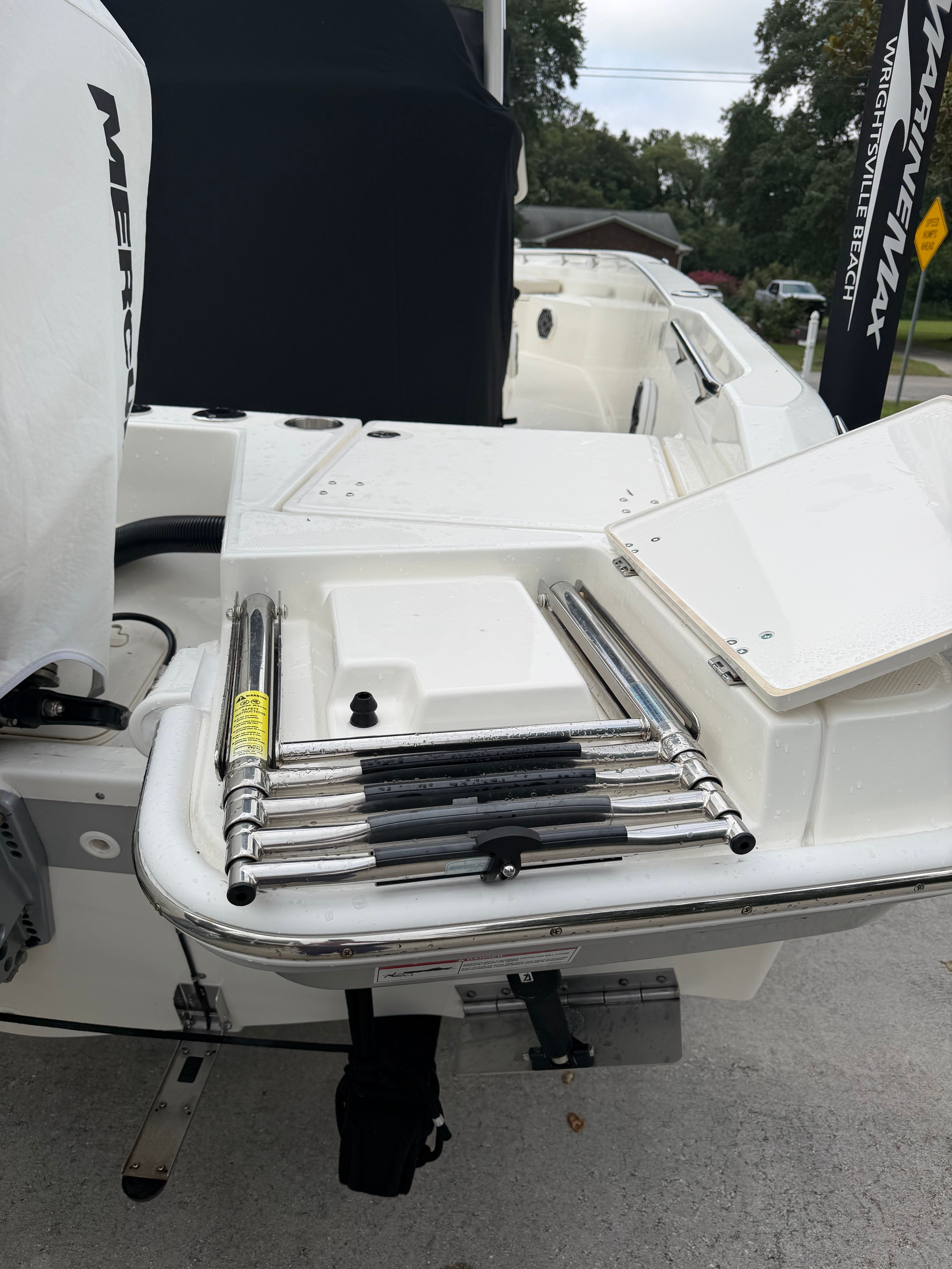 The image shows the stern of a Boston Whaler 220 Dauntless with a swim ladder.