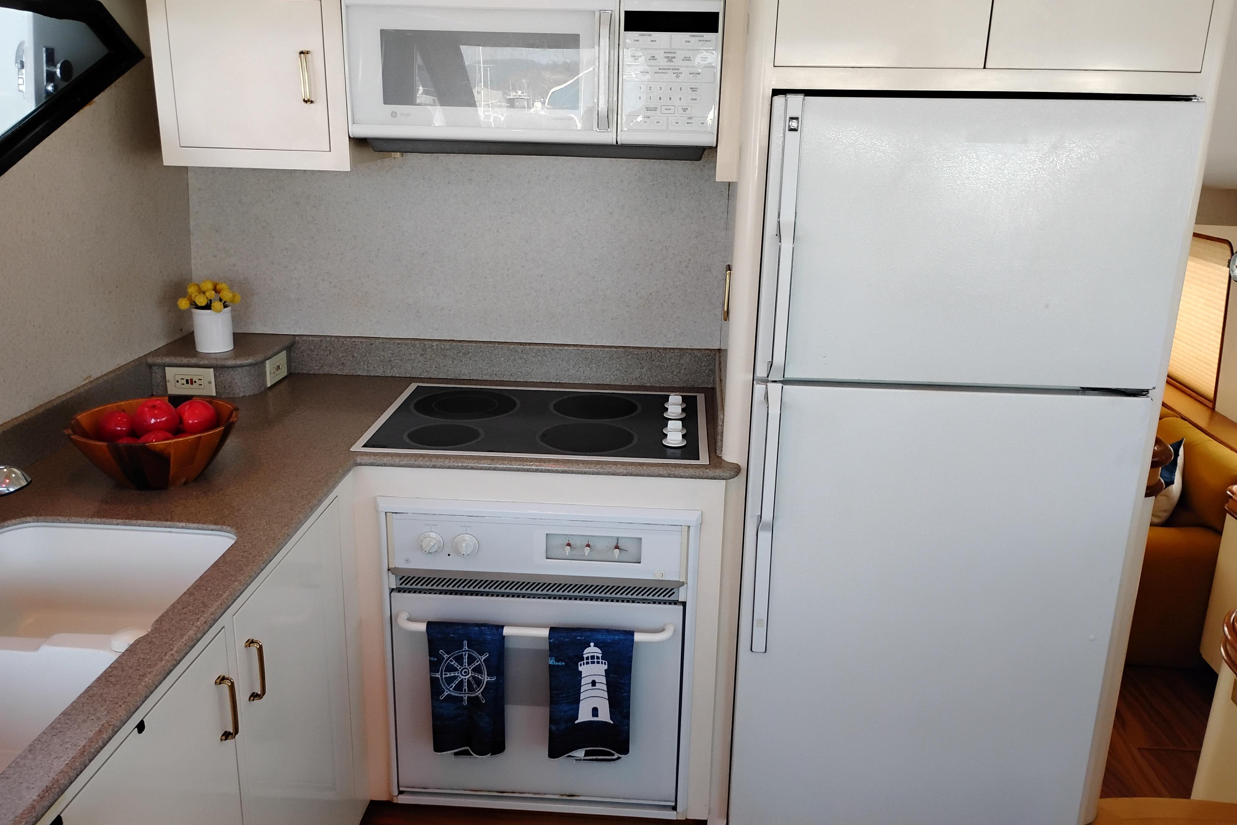 Kitchen area of 1995 Queenship 62 Pilothouse Motor Yacht with modern appliances.