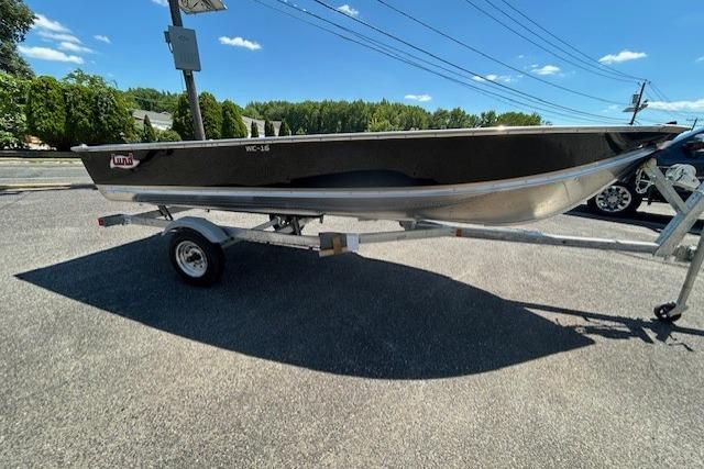 2027 Lund WC 16 boat on trailer, parked outdoors under clear blue sky.