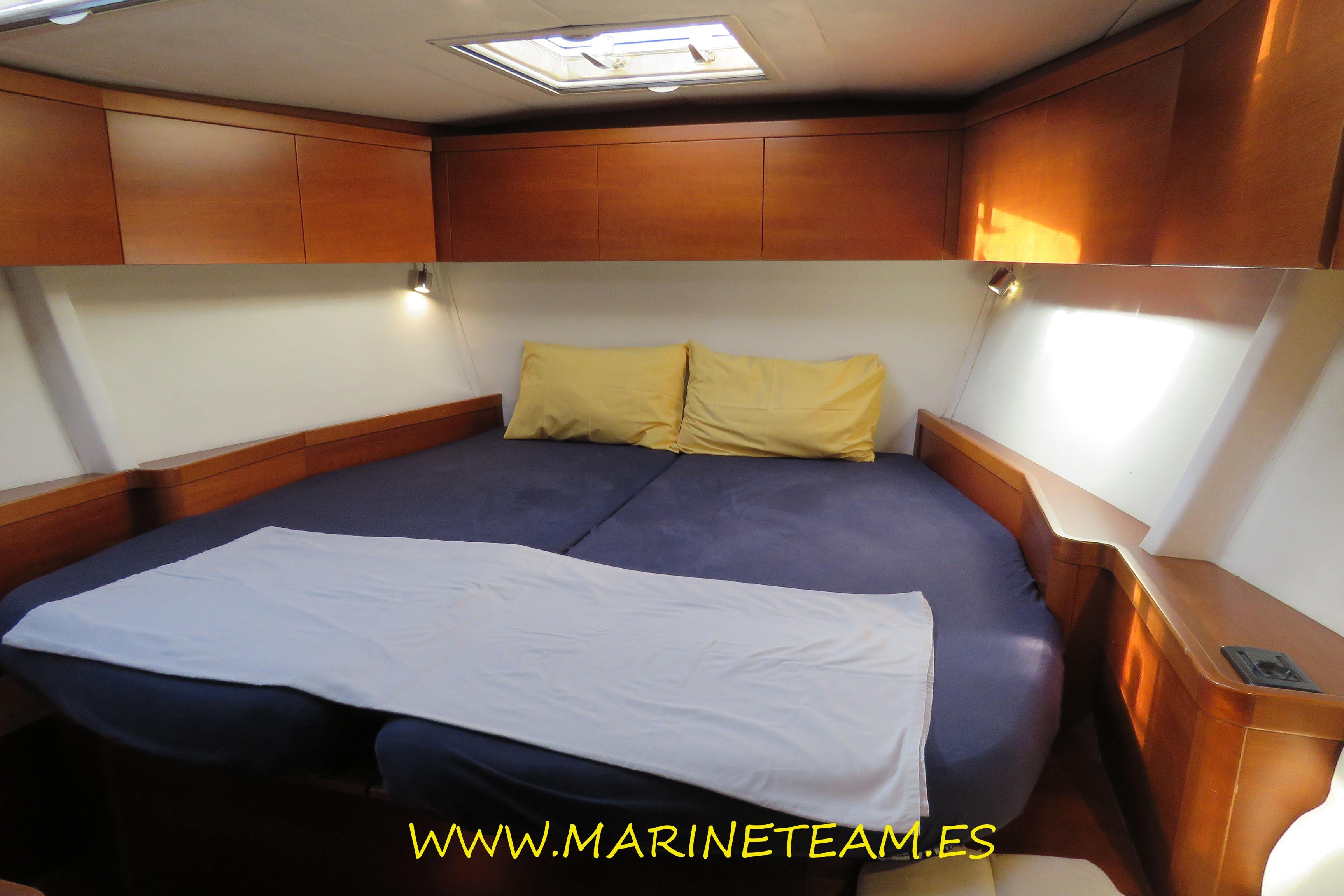 Luxurious cabin interior of 2005 Shipman 50 yacht with cozy bedding.