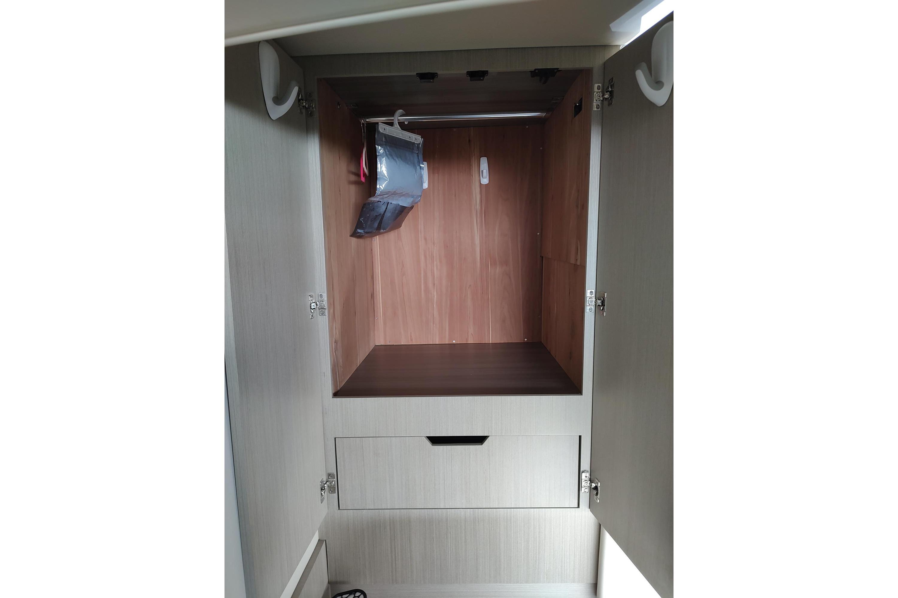 2021 Regal 42 Fly yacht interior closet with wooden finish and storage drawer.