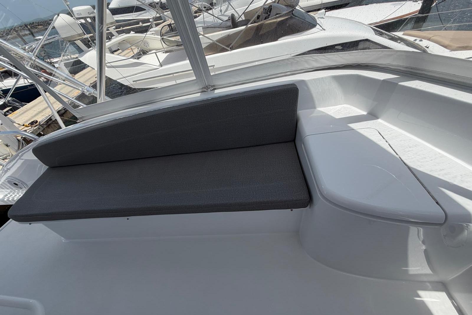 2003 Hatteras 54 Convertible yacht seating area with gray cushions and sleek design.