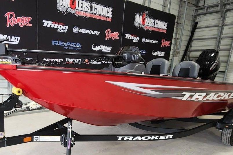 2026 Tracker Super Guide V-16 SC boat in showroom with promotional banners.