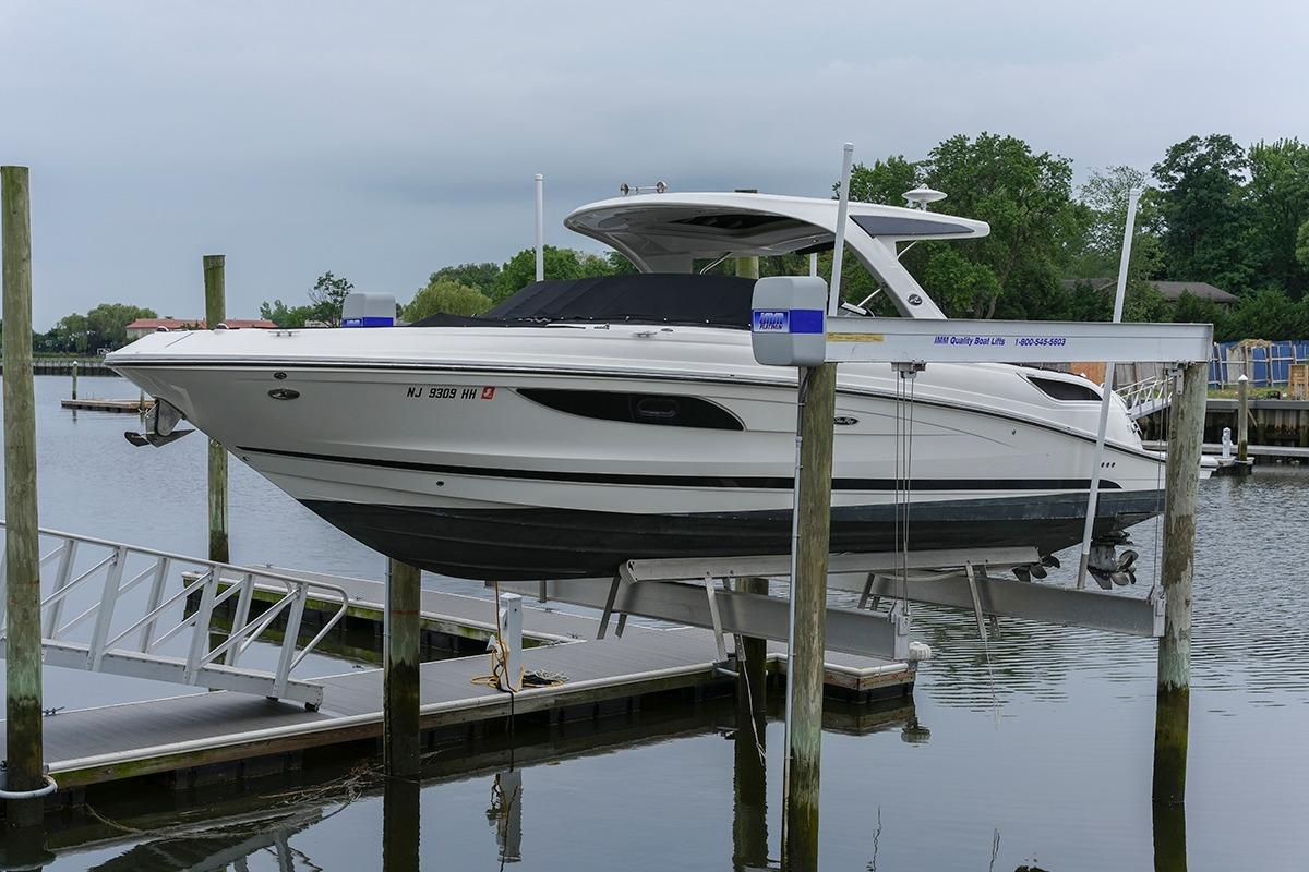 2018 Sea Ray SLX 350 boat on lift at marina, surrounded by calm water and greenery.