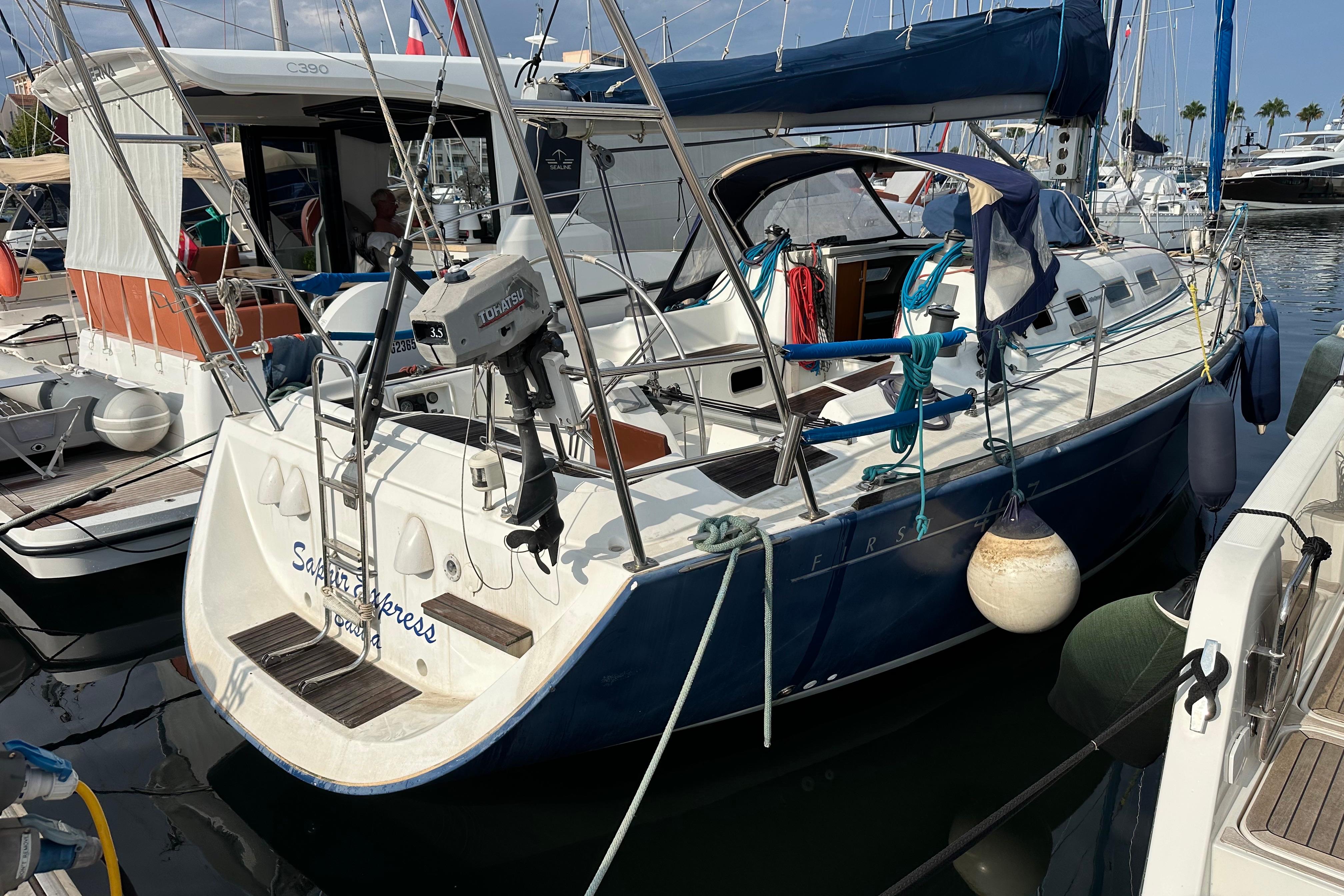 2003 Beneteau First 40.7 sailboat docked in marina, featuring blue hull and deck equipment.