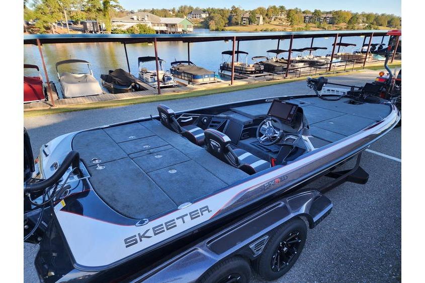 2026 Skeeter FXR21 Limited bass boat docked by a scenic lake.
