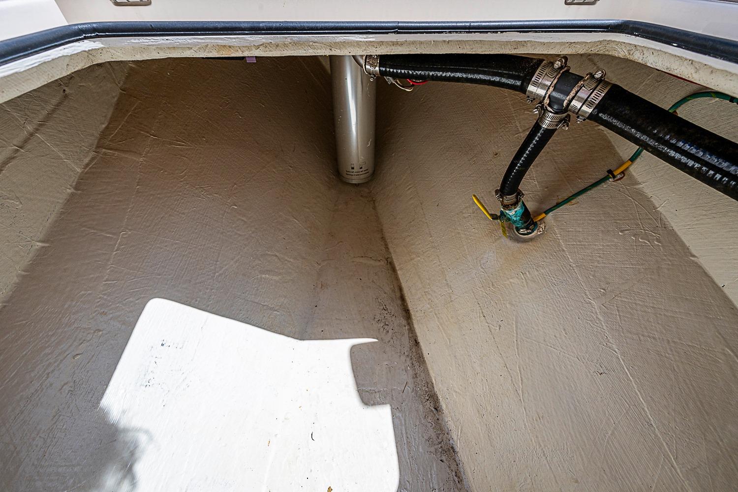2019 Cobia 320 Center Console storage compartment with visible plumbing and fittings.