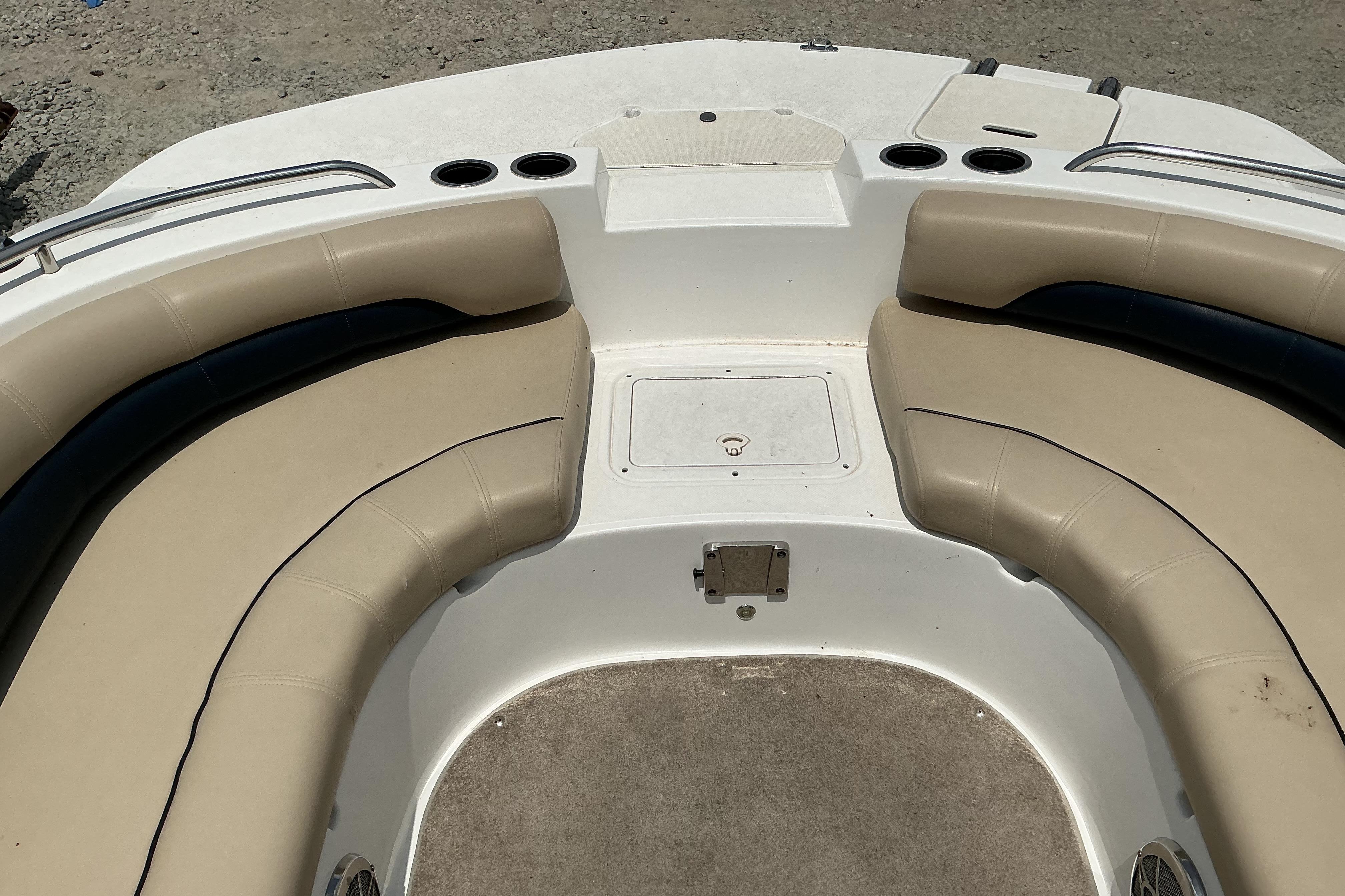 2015 Hurricane SunDeck 187 IO boat interior with beige seating and cup holders.