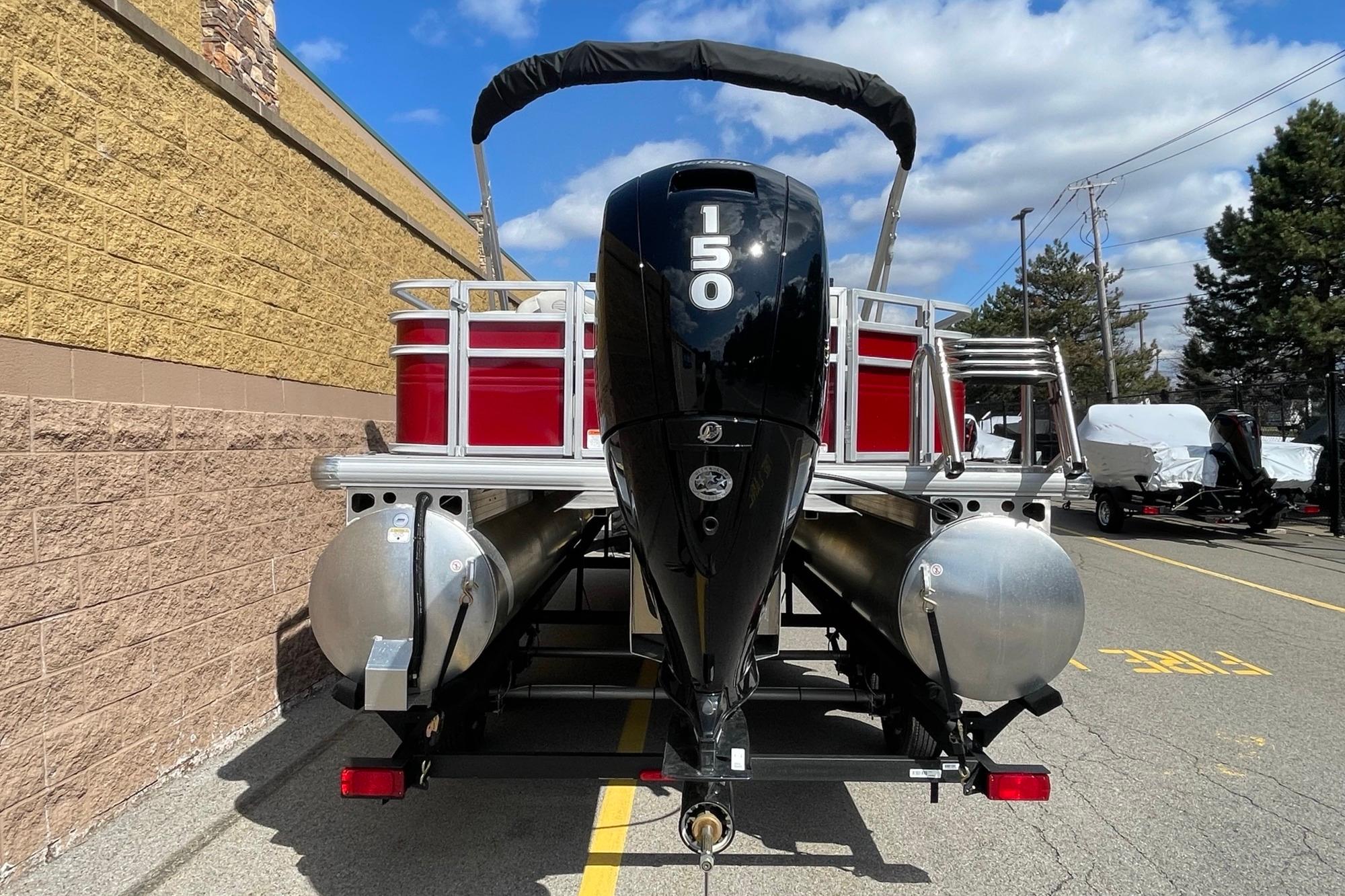 2026 Sun Tracker Fishin' Barge 22 DLX pontoon boat with powerful outboard motor.