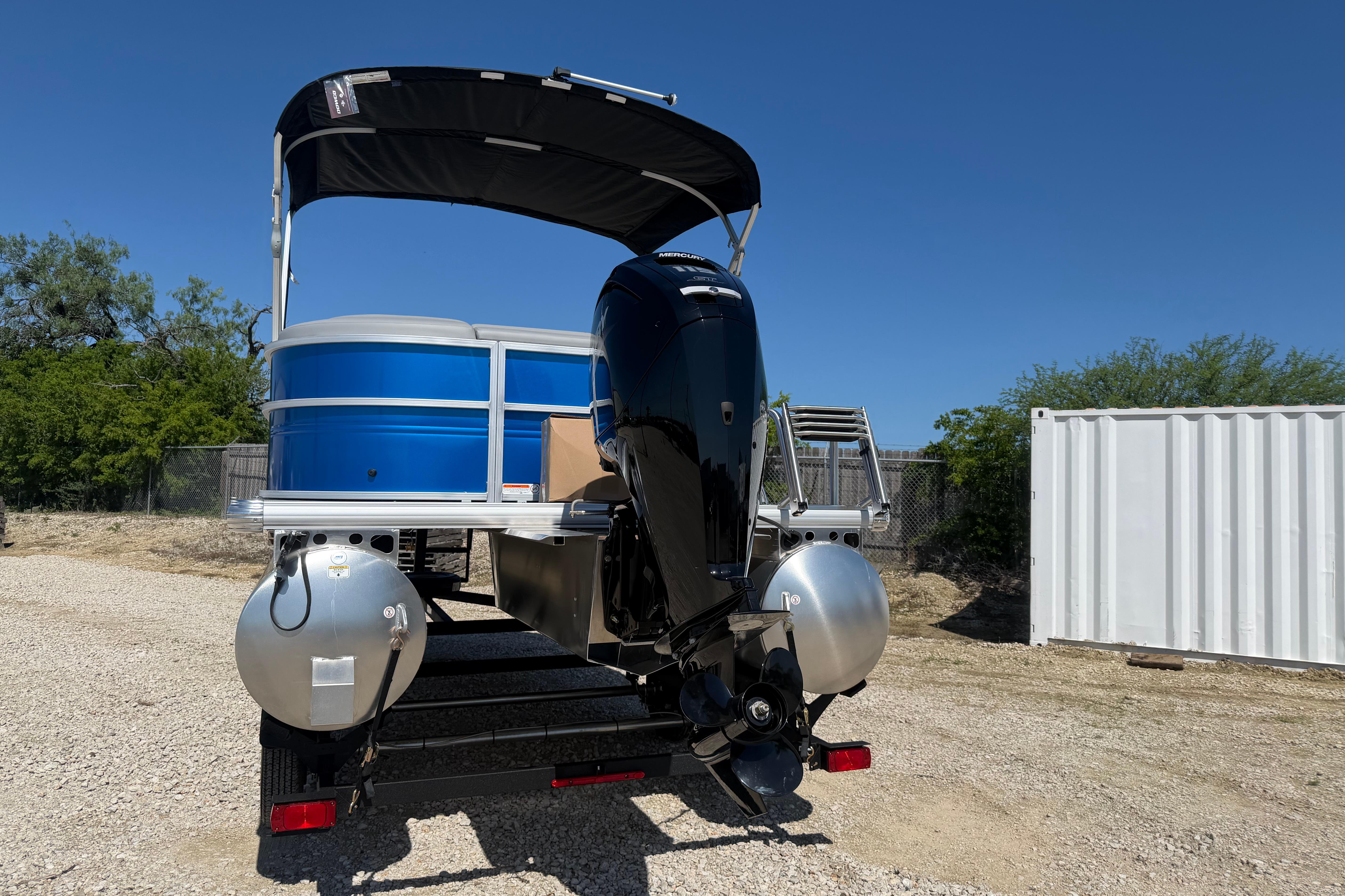 2026 Sun Tracker Party Barge 20 DLX pontoon boat with canopy and outboard motor.