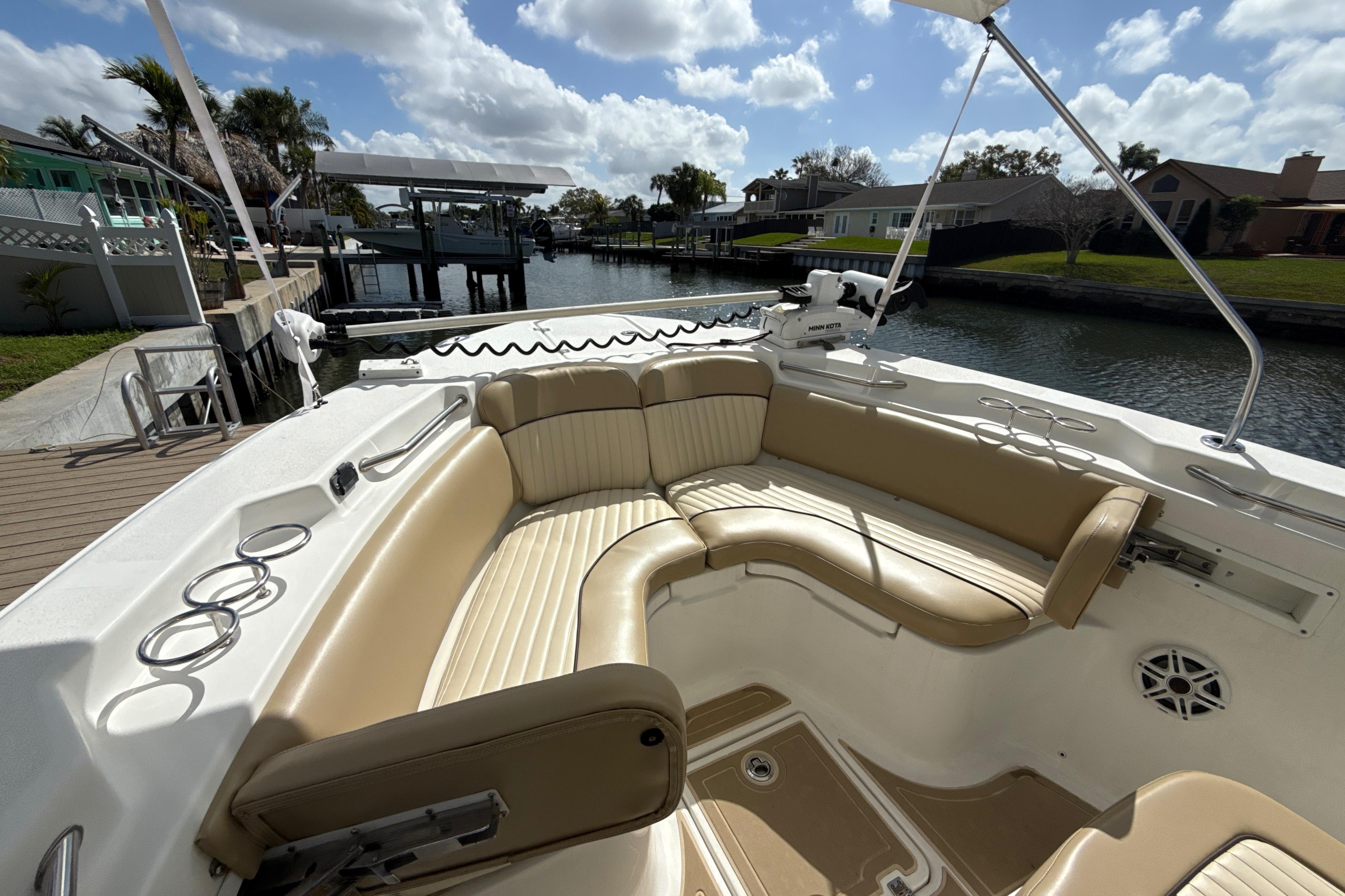 2016 Sea Fox 266 Commander boat with spacious seating and cup holders, docked by a canal.