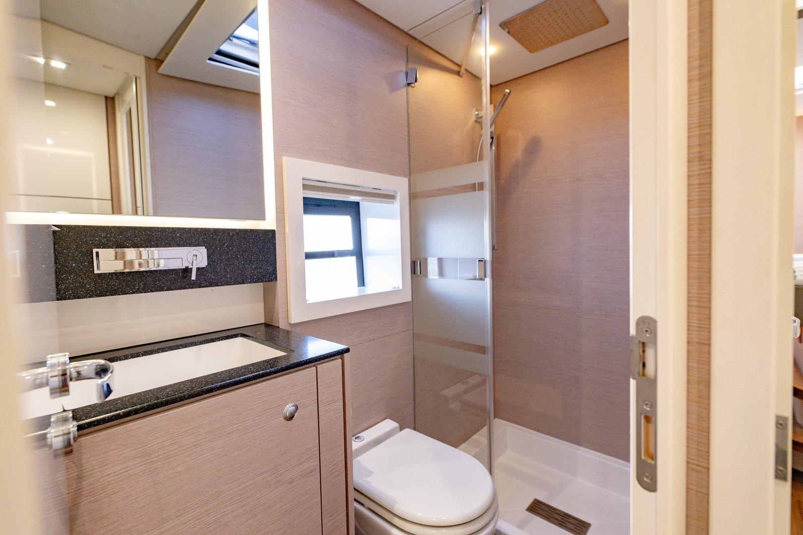 Modern bathroom interior on 2023 Aventura 50 yacht, featuring sleek fixtures and a glass shower.