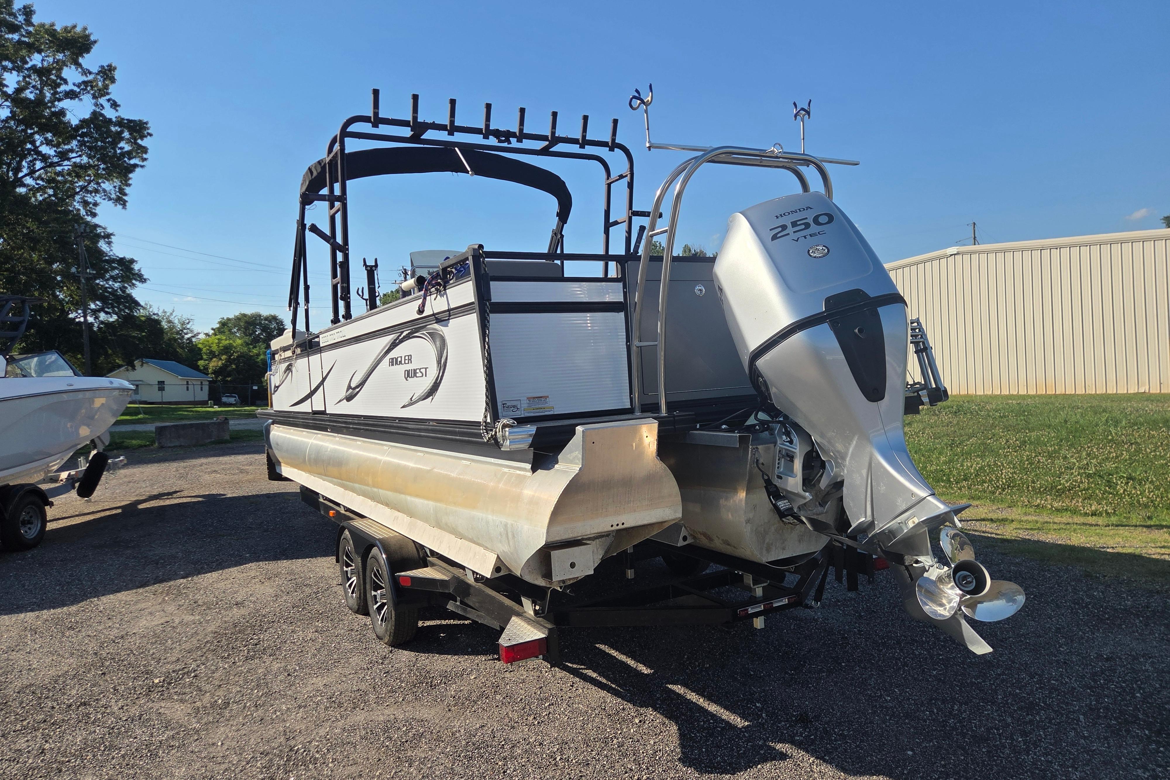 2024 Angler Qwest 8526 Pro Troll boat with Honda 250 engine, parked outdoors.