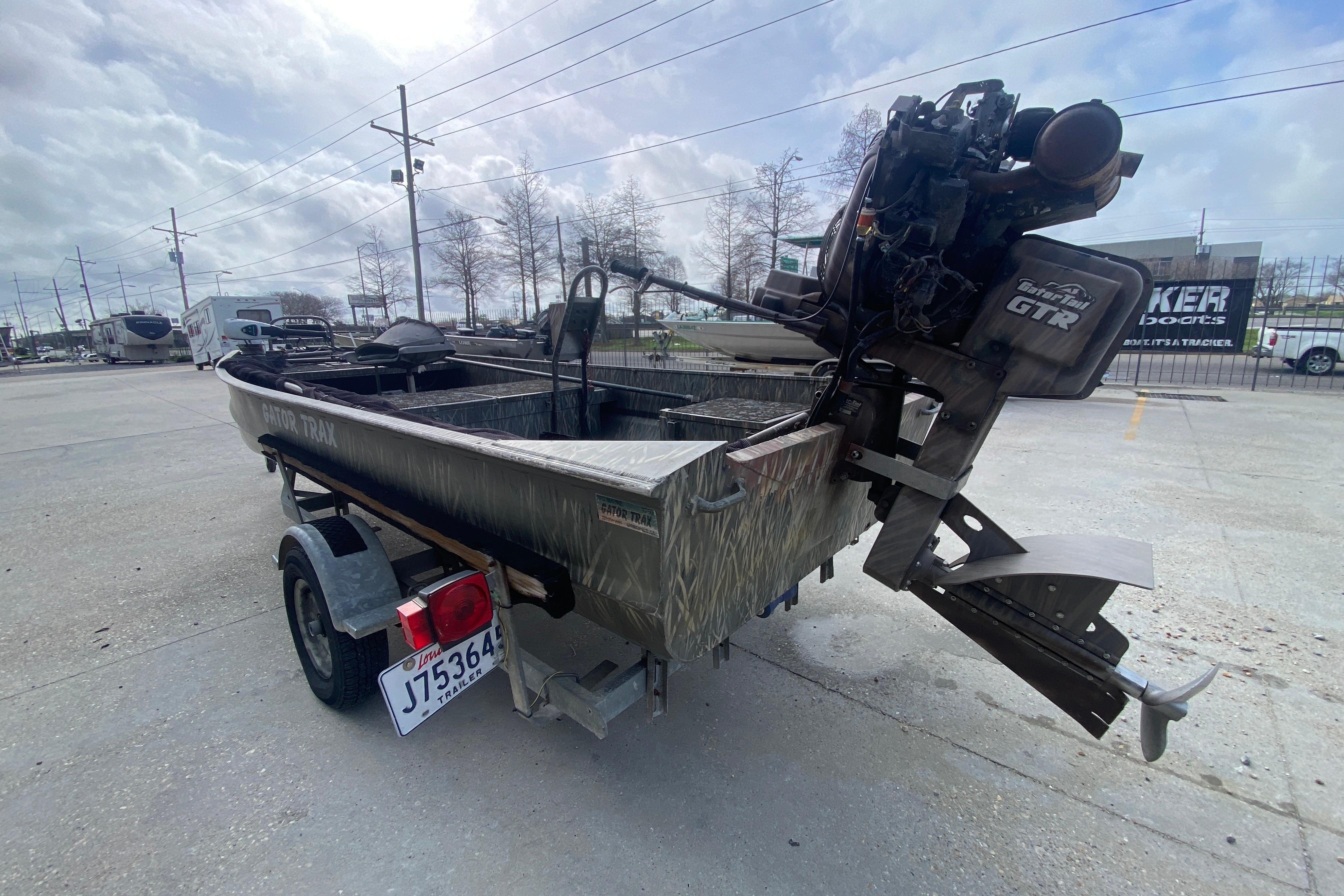2009 Gator Trax MUD BUDDY 17 X 50 boat with trailer in parking lot.
