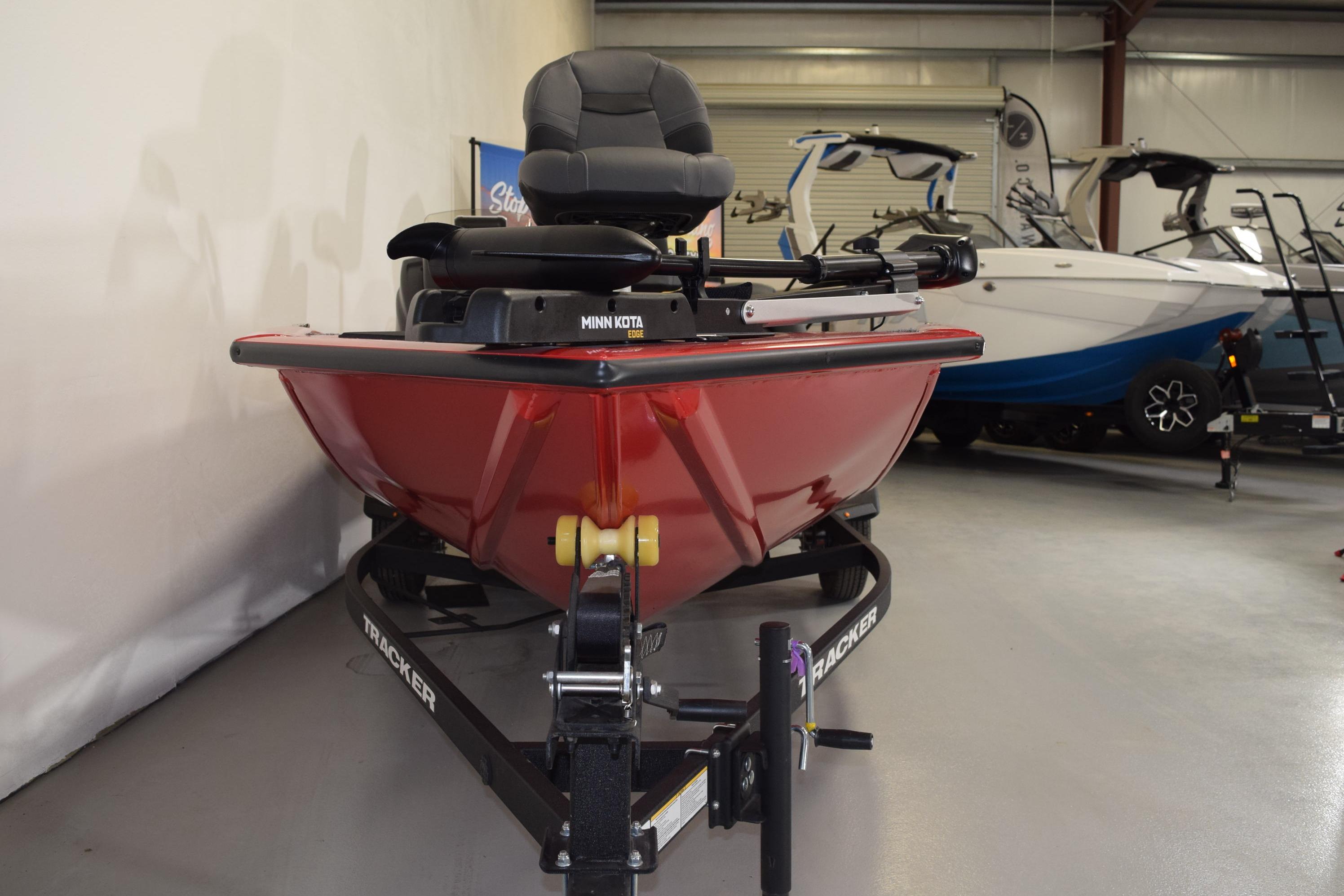 2026 Tracker Pro Team 175 boat in showroom, featuring red hull and Minn Kota trolling motor.
