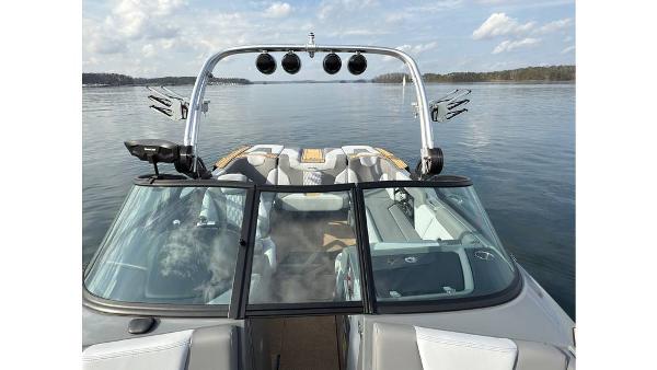 2023 MasterCraft XT22 boat on calm lake with clear sky and modern design.