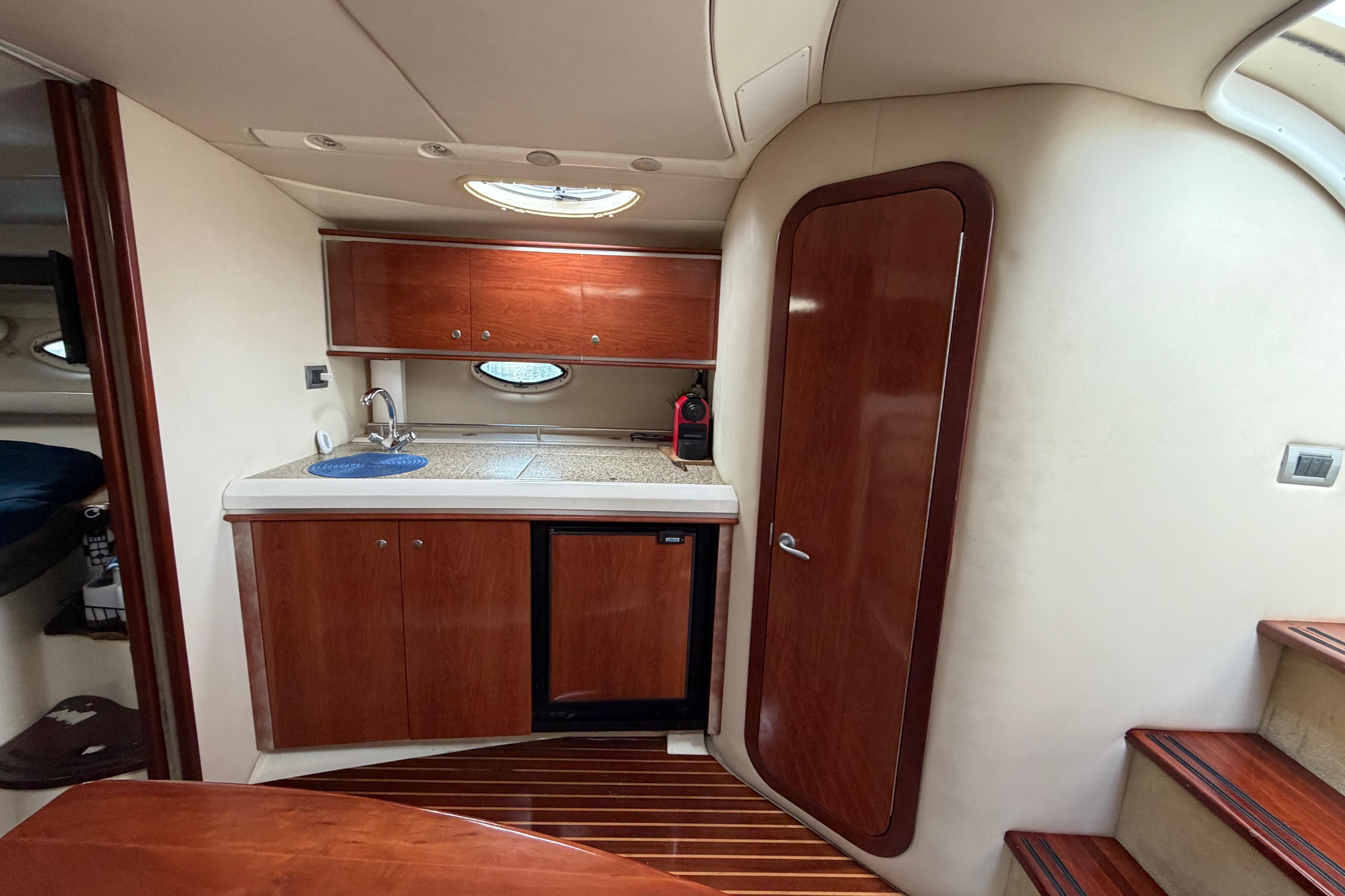 Interior of 2007 Monterey 350 Sport Yacht with kitchenette and wooden cabinetry.