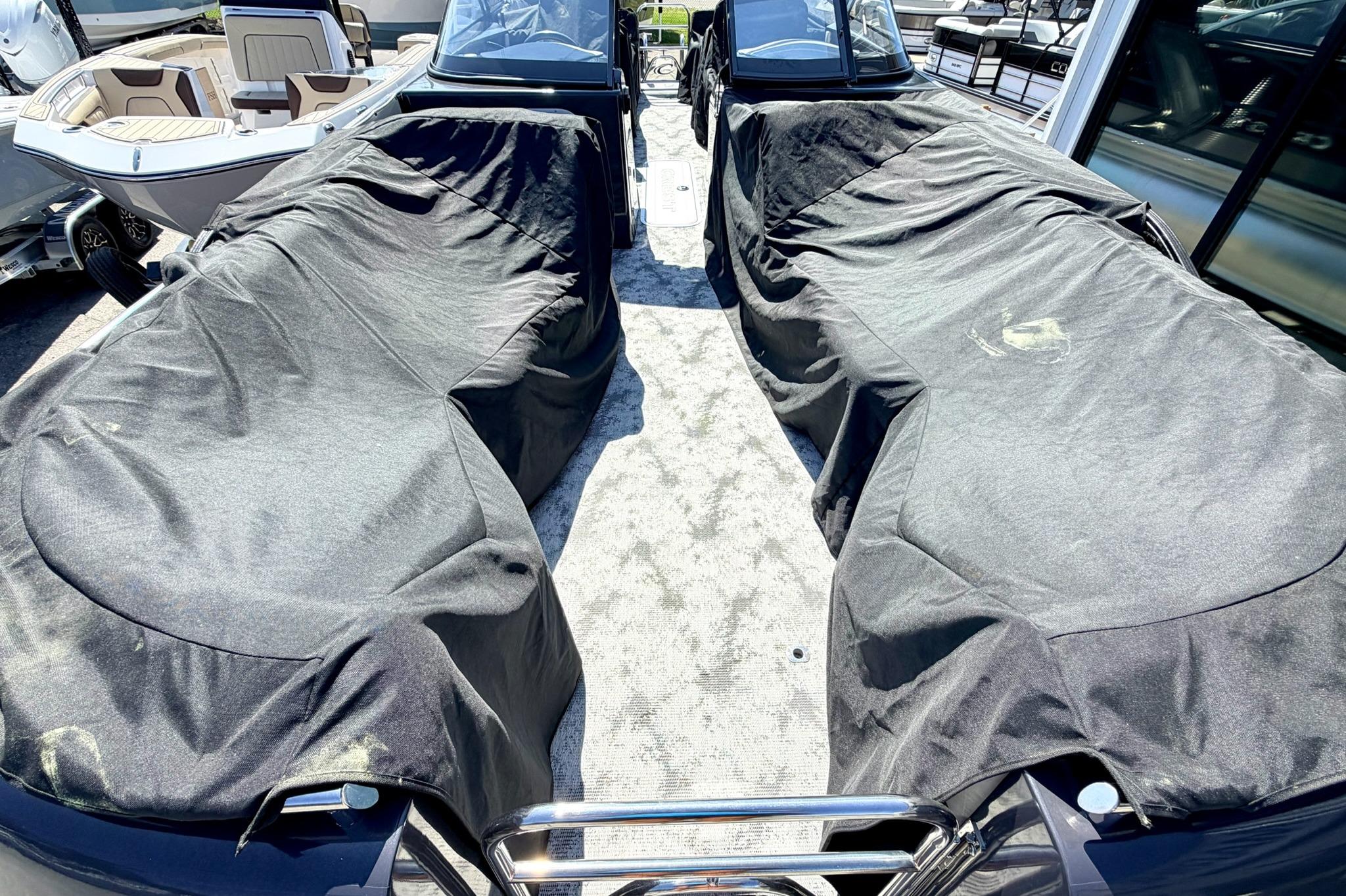 2022 Crest Continental 270 NX-CS Twin boat with protective covers in a showroom.