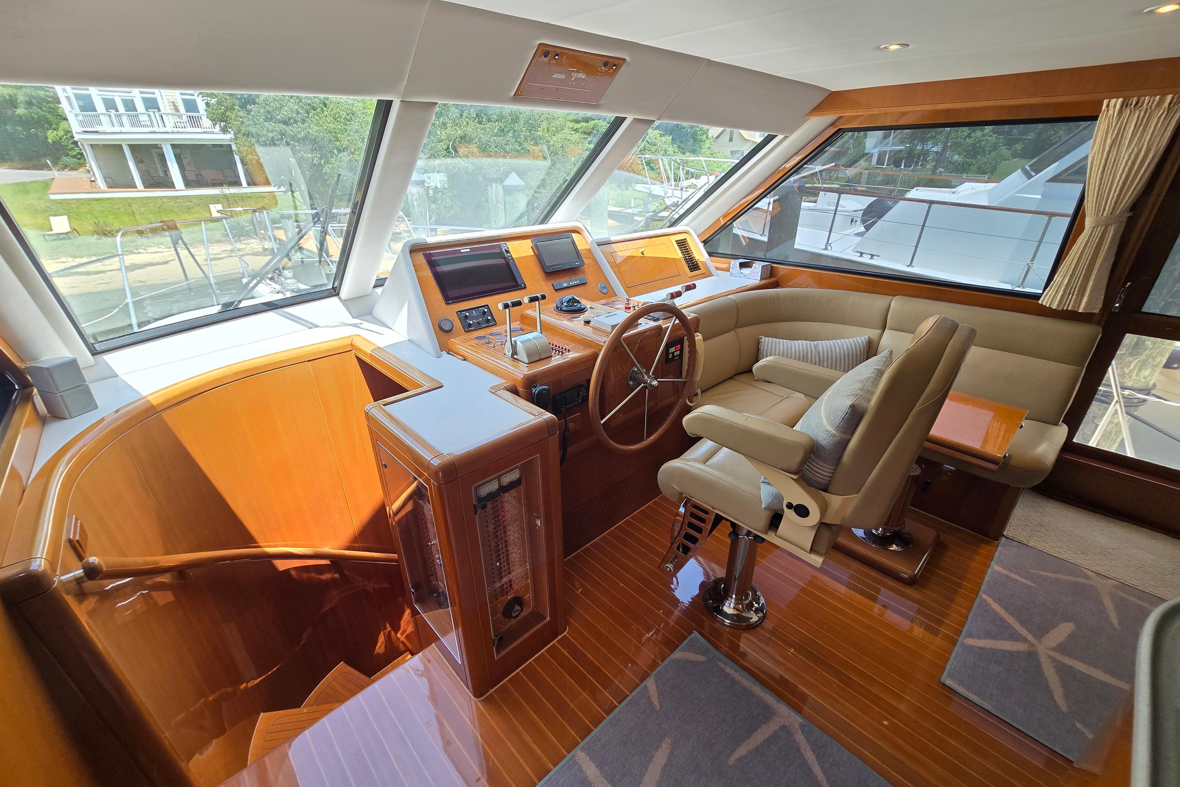 Luxurious 2004 Grand Harbour 58 yacht interior with helm, plush seating, and polished wood finishes.