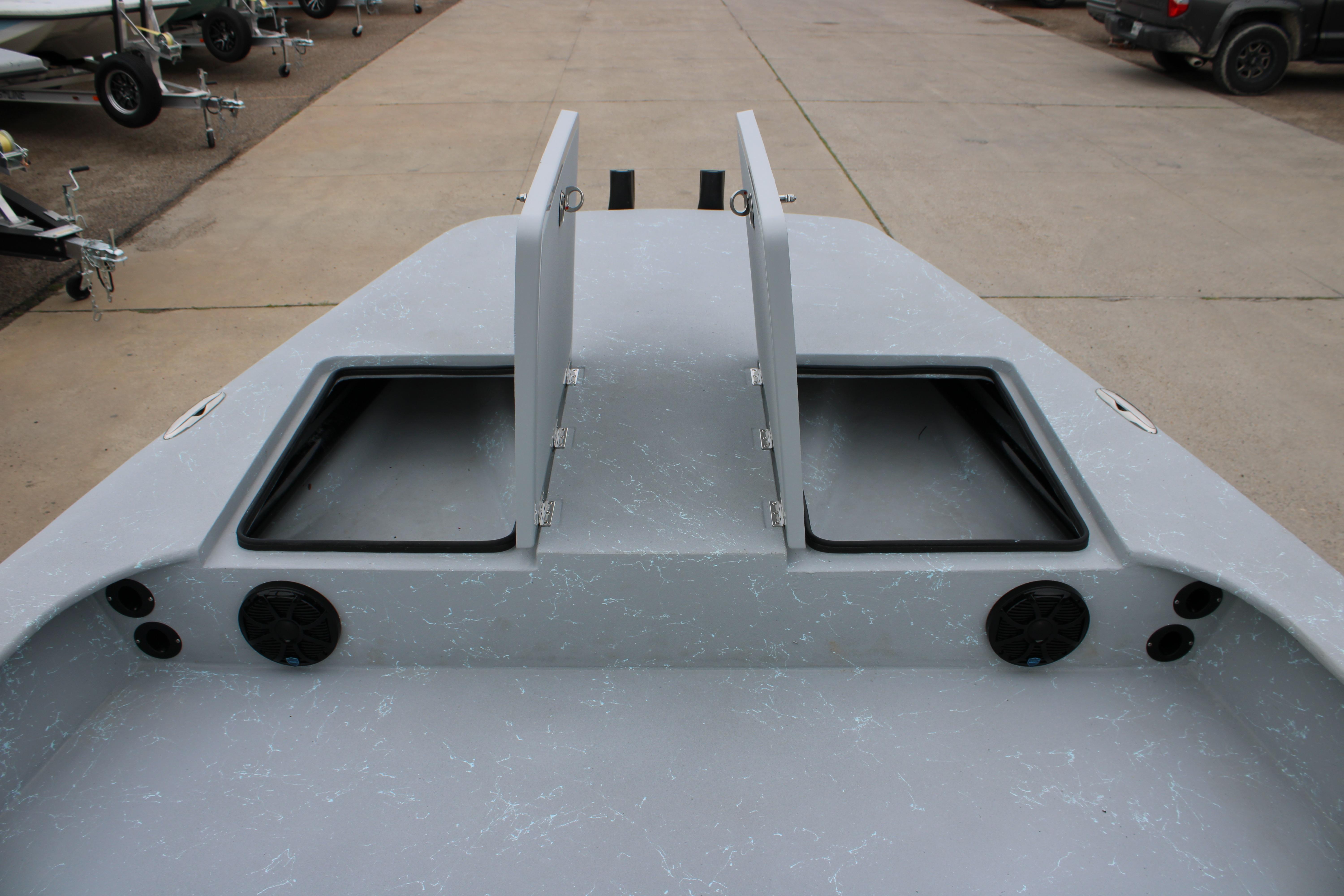 2026 Freedom Boats 24 Defender deck with open storage compartments and speakers.