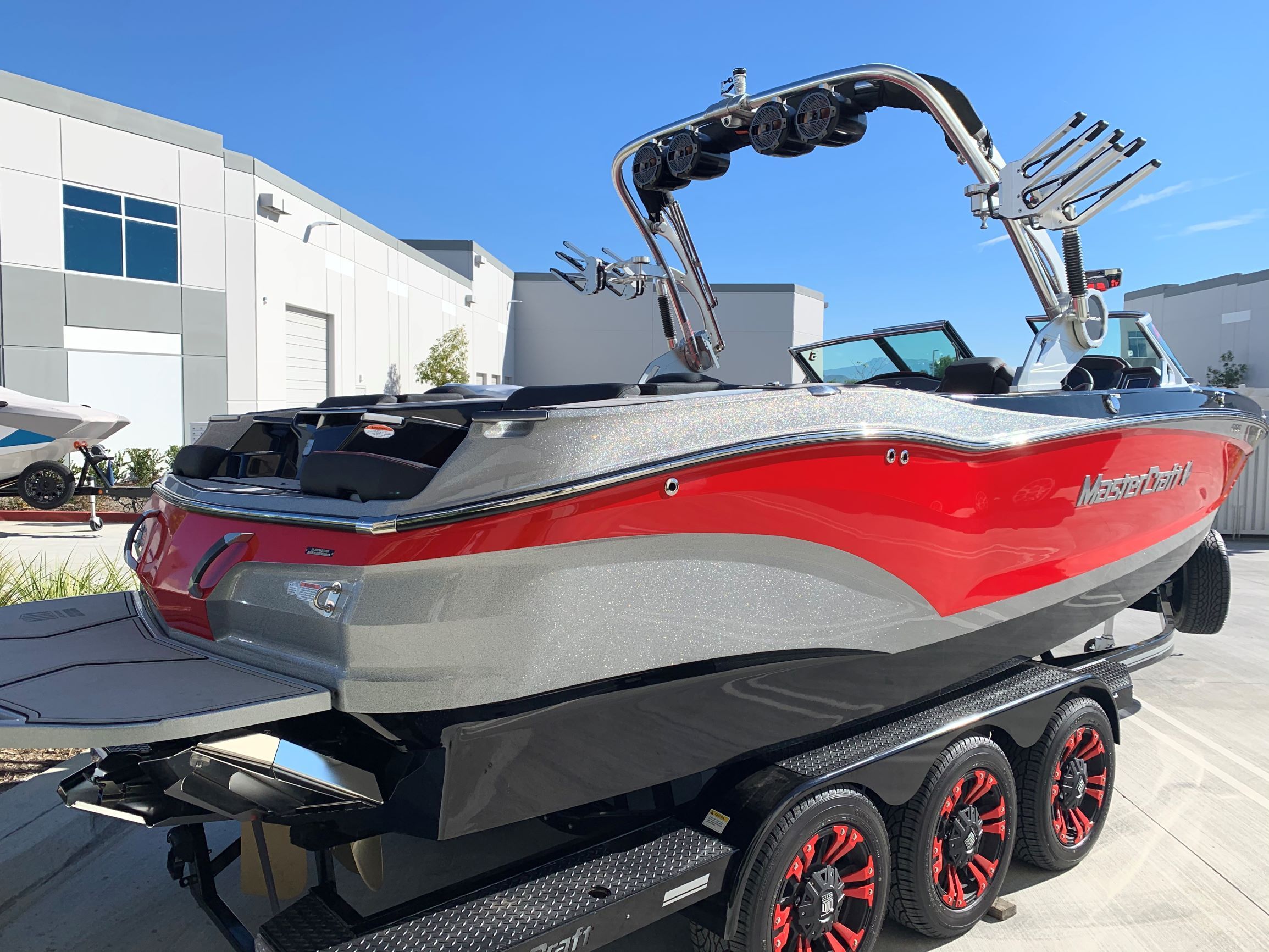 A 2020 MasterCraft X24 boat on a trailer. It features a red and gray color scheme.