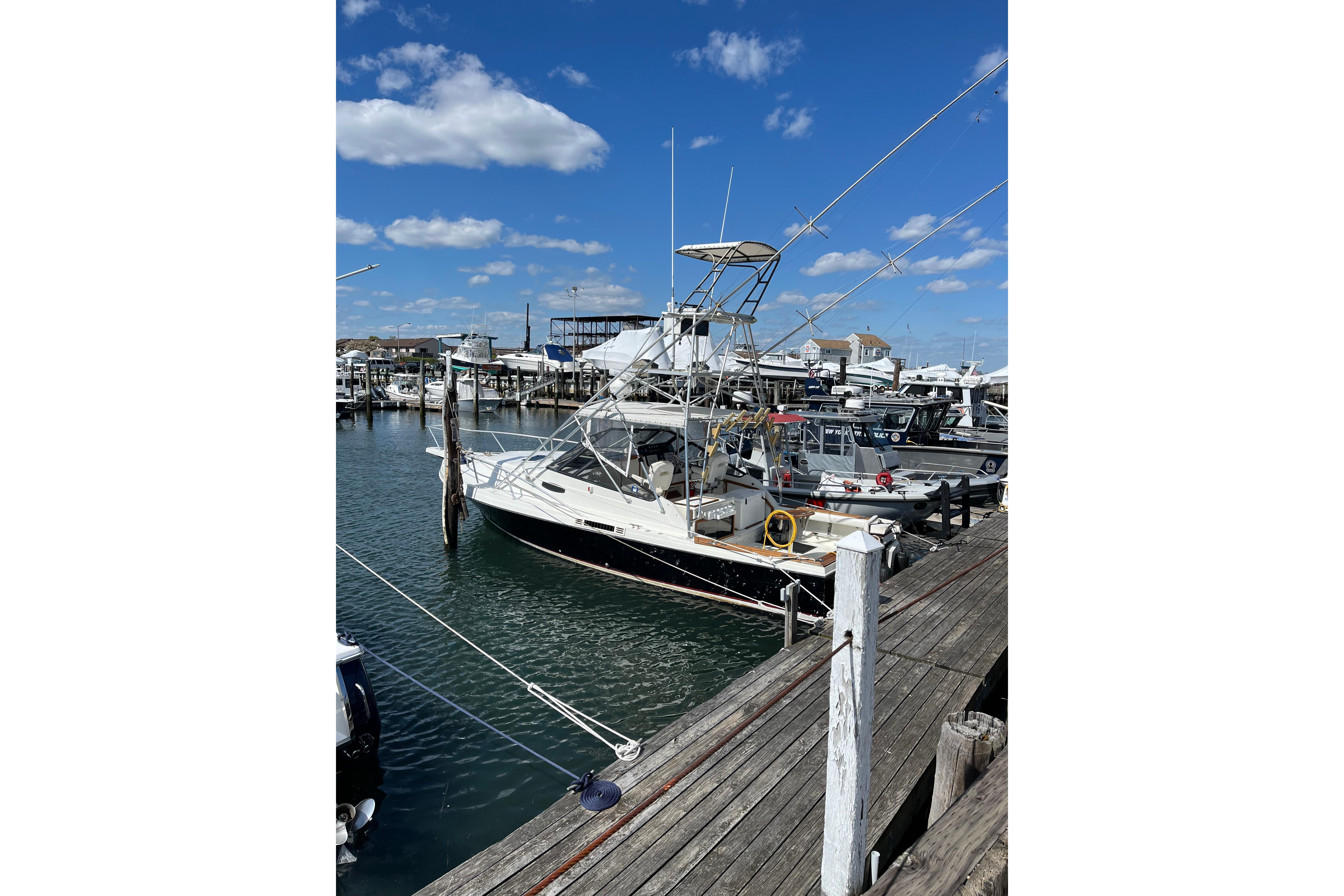 1989 Blackfin 31 Combi boat docked at a marina under a clear blue sky.