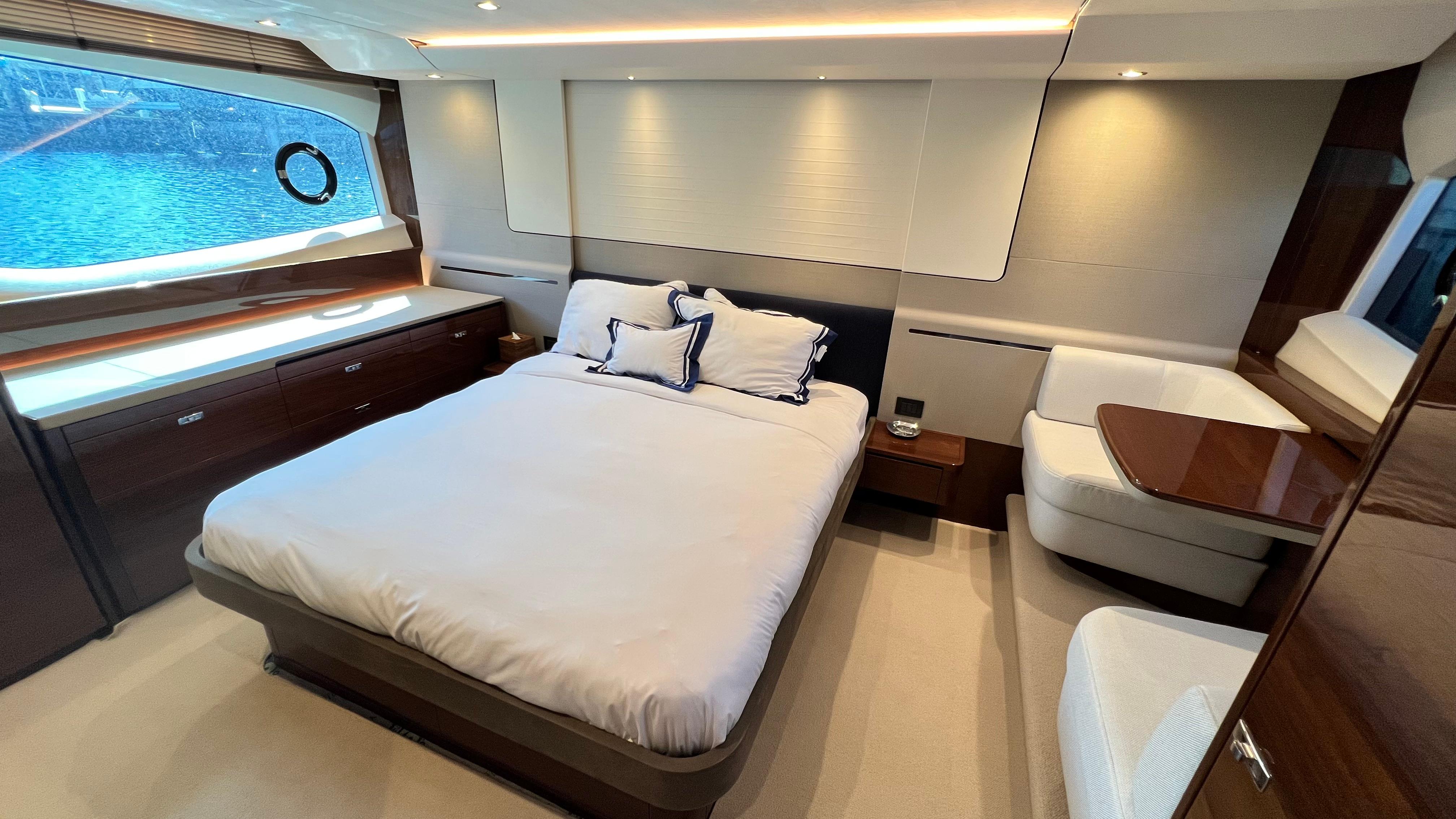 Luxurious bedroom interior of 2019 Princess F62 yacht with elegant furnishings and large window view.