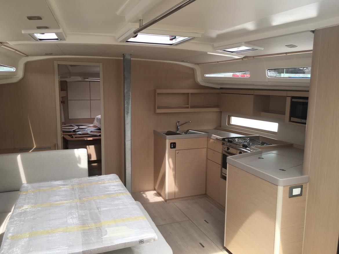 Modern interior of 2025 Beneteau Oceanis 40.1 yacht, featuring kitchen and dining area.