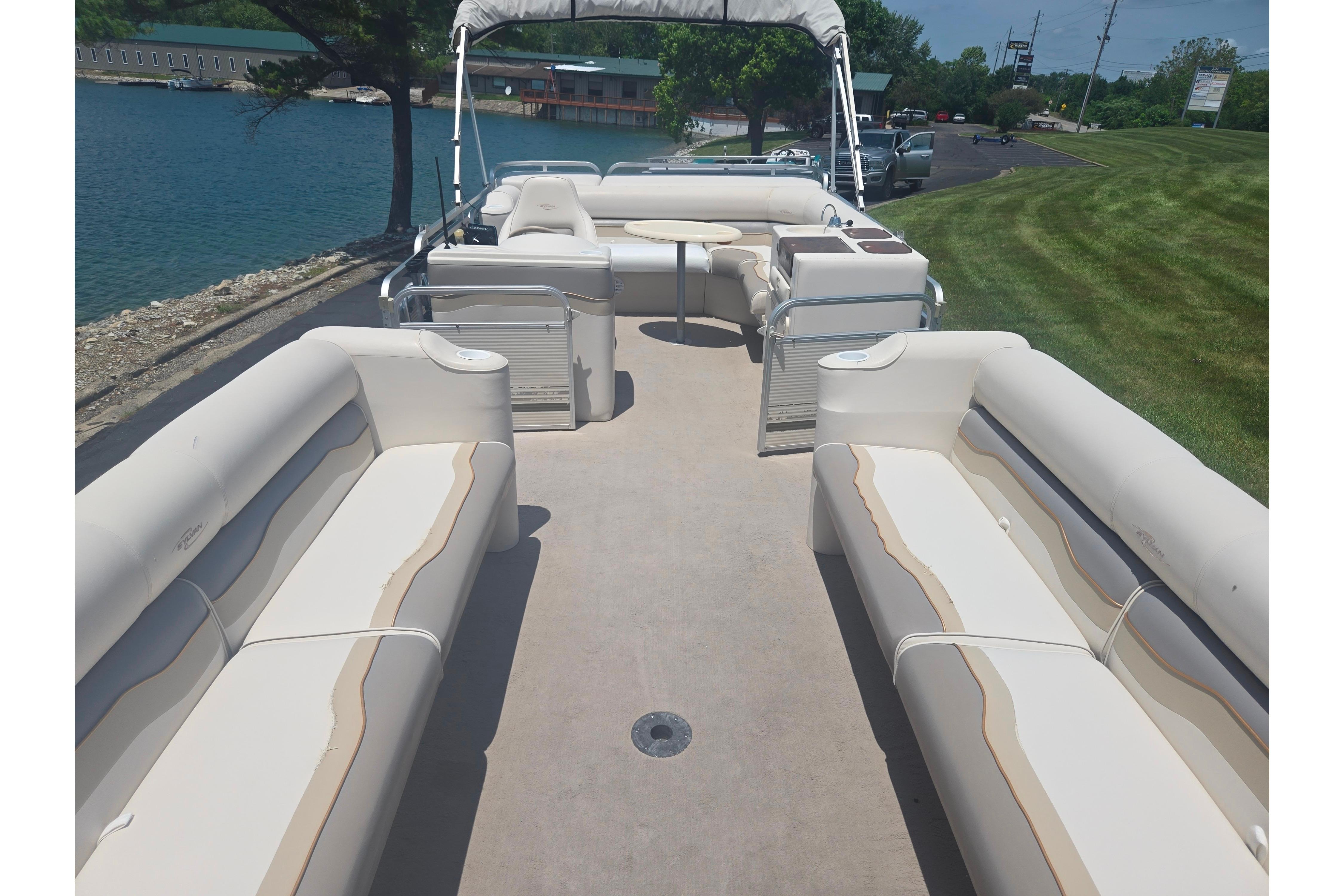 2000 Sylvan 824 Elite Cruise pontoon boat with spacious seating and scenic lake view.
