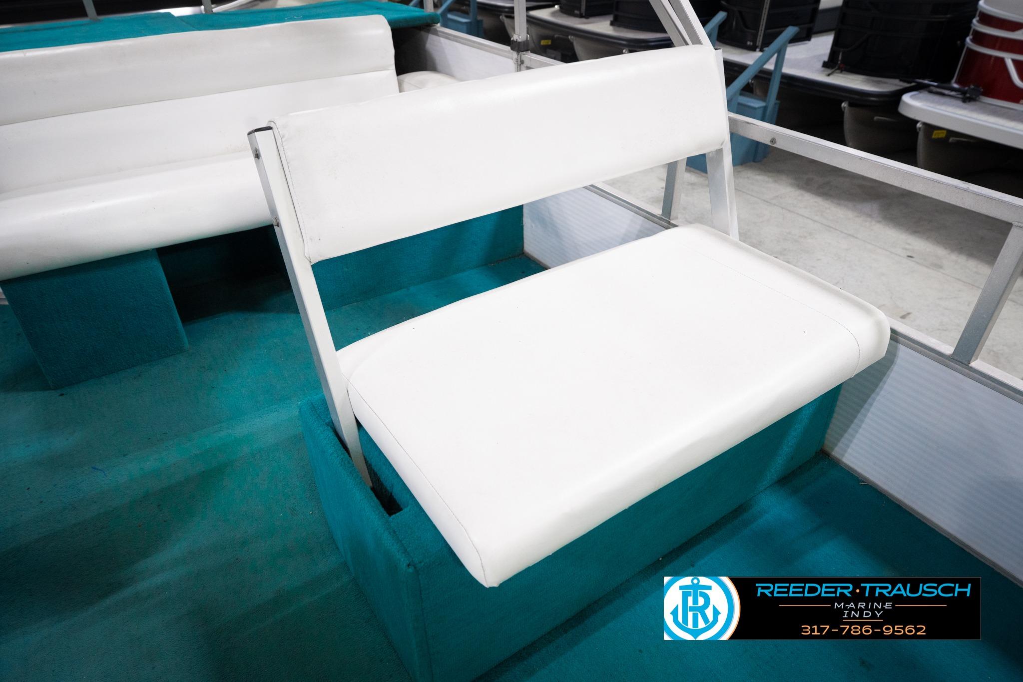 White seating on a 1992 Godfrey Sweetwater boat, featuring teal flooring.