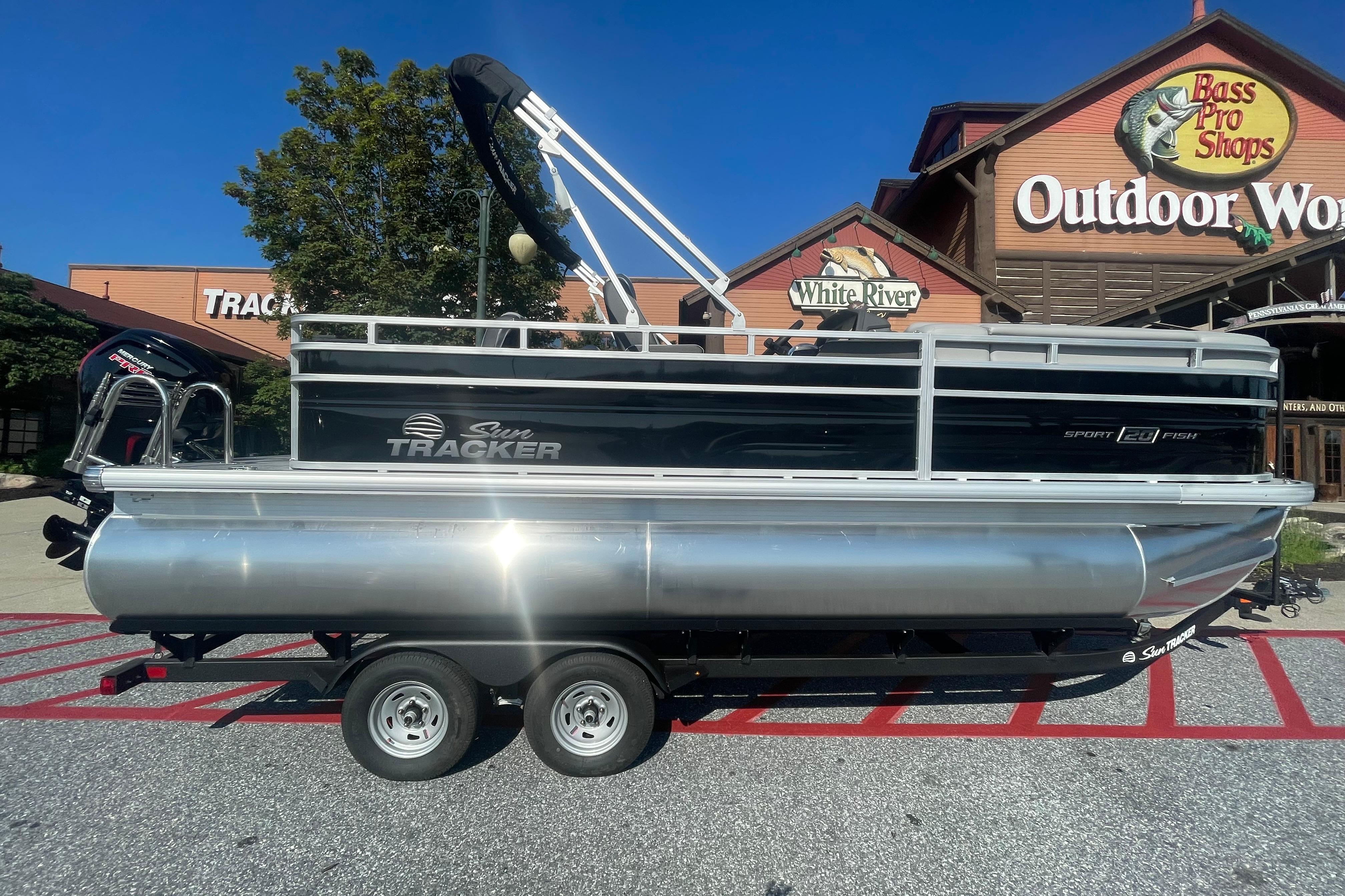 2026 Sun Tracker SportFish 20 DLX pontoon boat outside Bass Pro Shops.