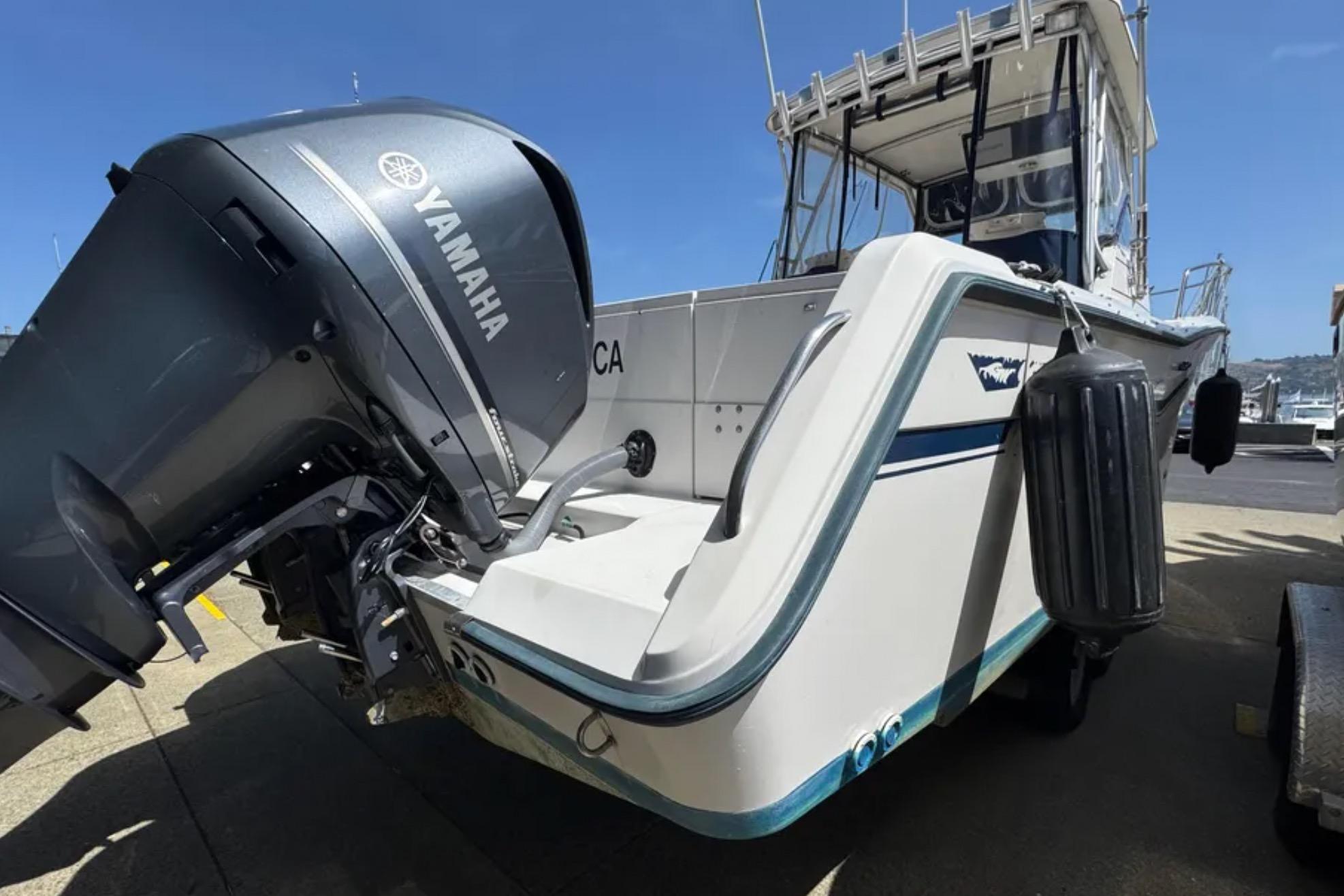 1990 Grady-White Marlin 280 boat with Yamaha outboard motor, docked under clear blue sky.