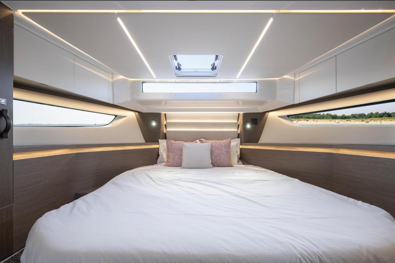 Luxurious interior cabin of 2026 Jeanneau NC 1295 Weekender with modern lighting and large bed.