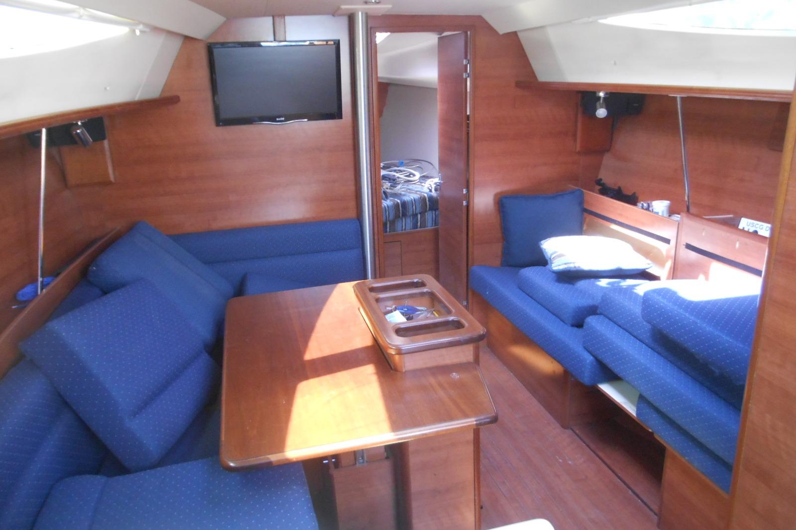 Interior of 2014 Marlow-Hunter 33 sailboat with blue seating and wooden finishes.
