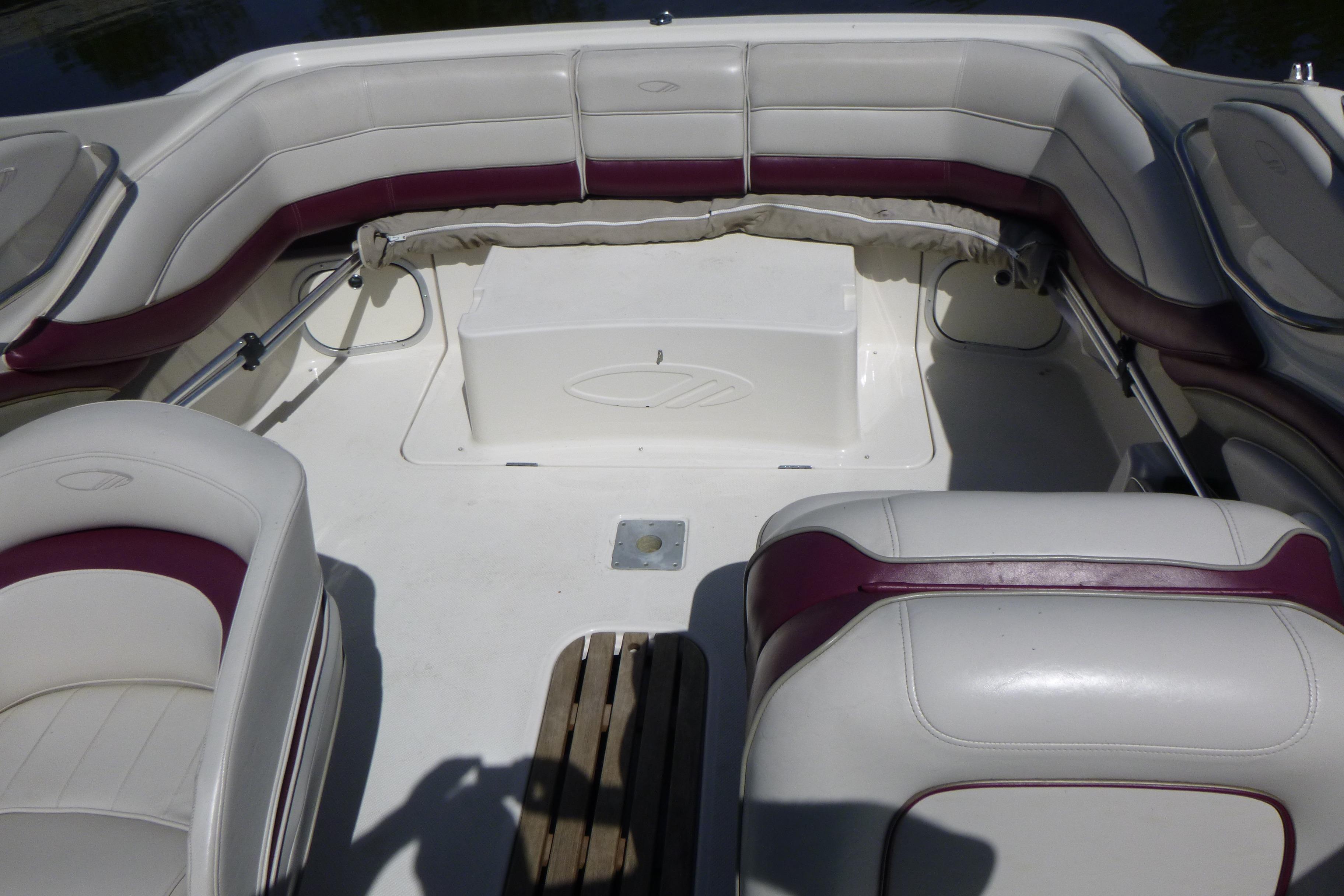 Interior of a 1998 Maxum 2300 SC boat with white and maroon seating.