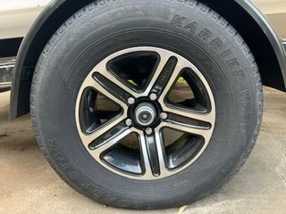 Close-up of a tire with a stylish rim on a concrete floor.