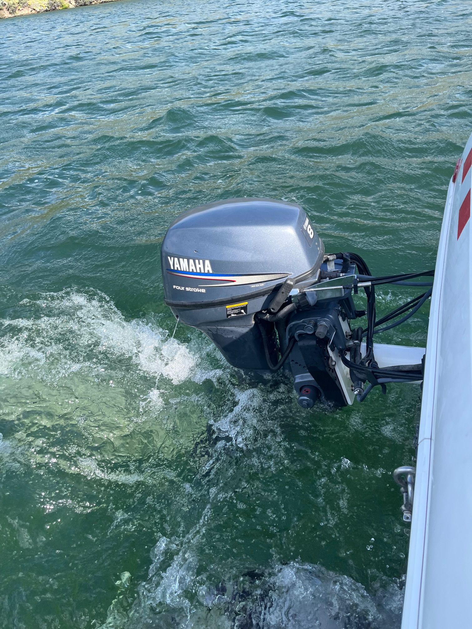 A Yamaha outboard motor on a boat in a lake.