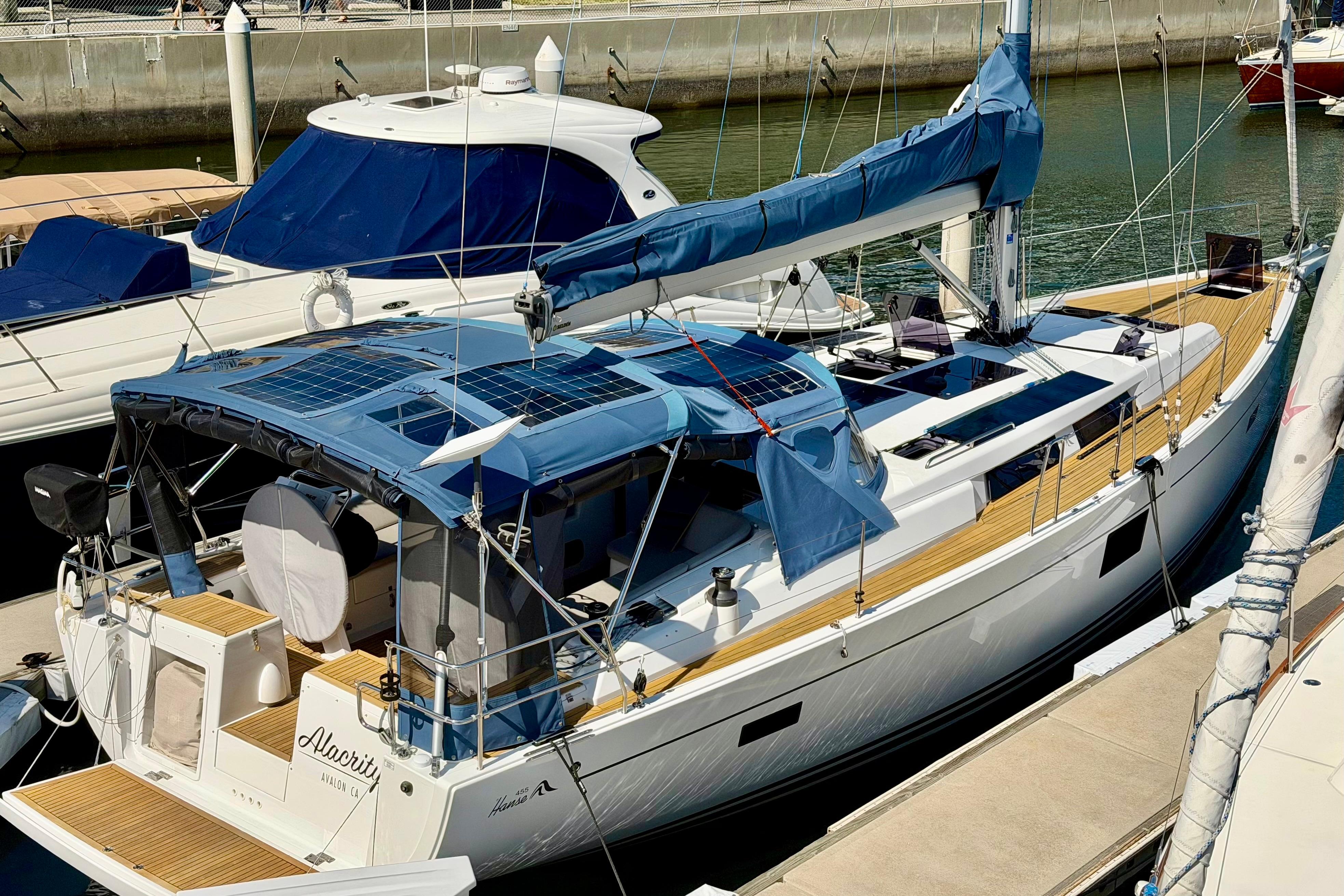 2016 Hanse 455 yacht docked at marina with blue canopy and solar panels.