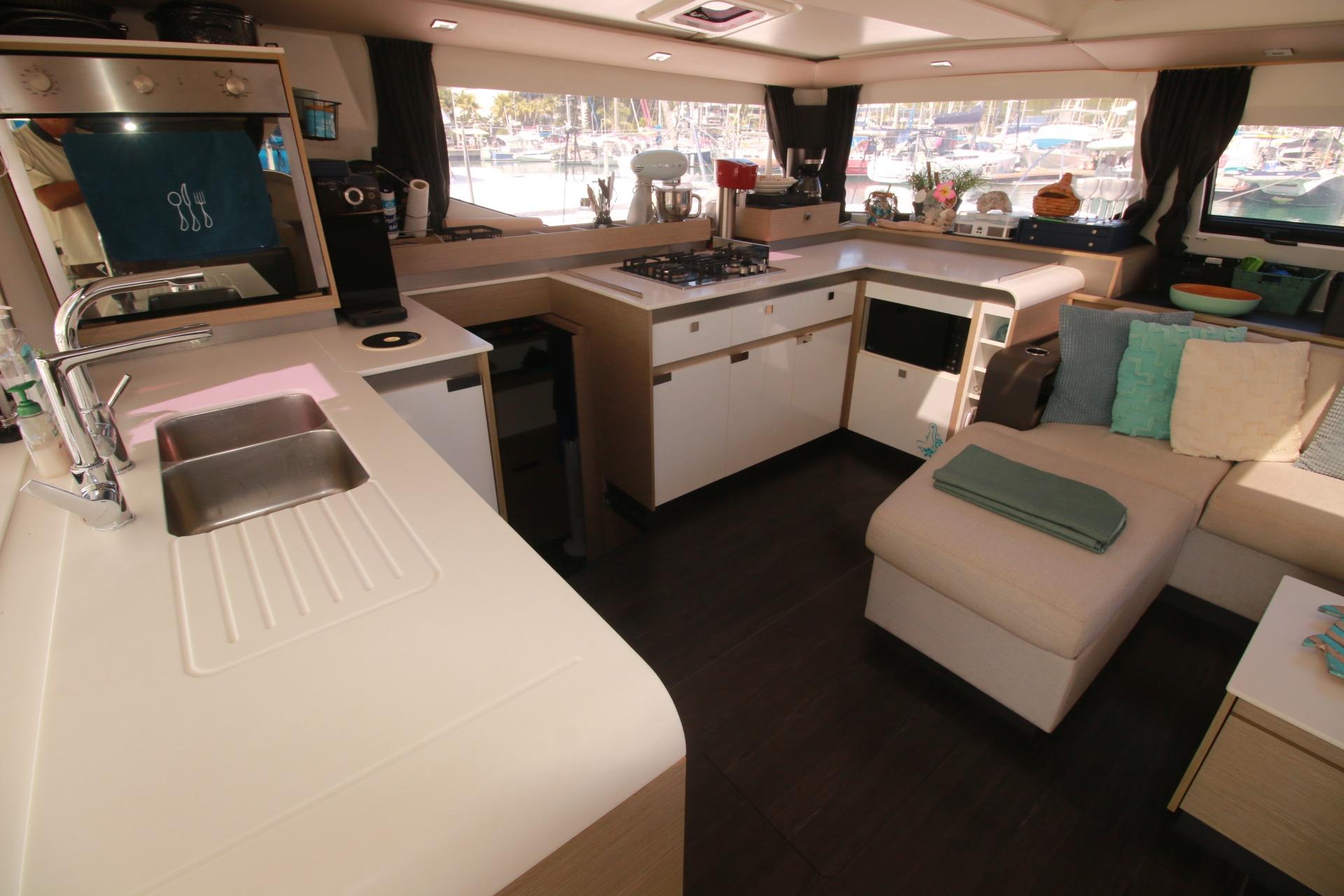 Modern kitchen and lounge area inside 2022 Fountaine Pajot Elba 45 Catamaran.