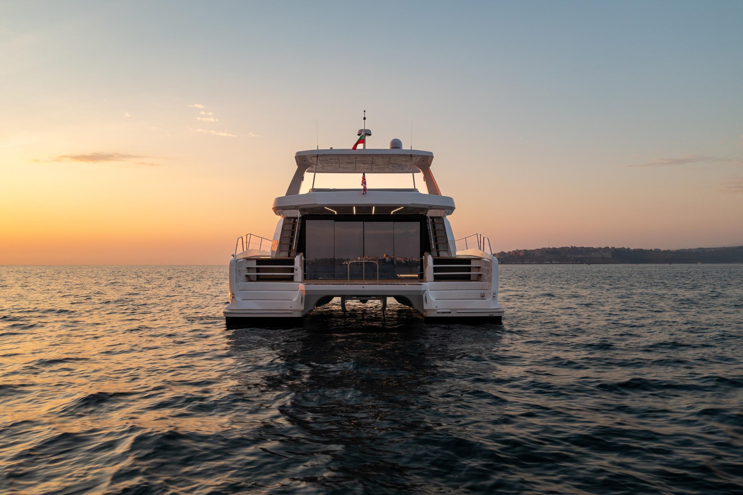 2025 Custom Omaya 50 Power Catamaran at sunset on open water.