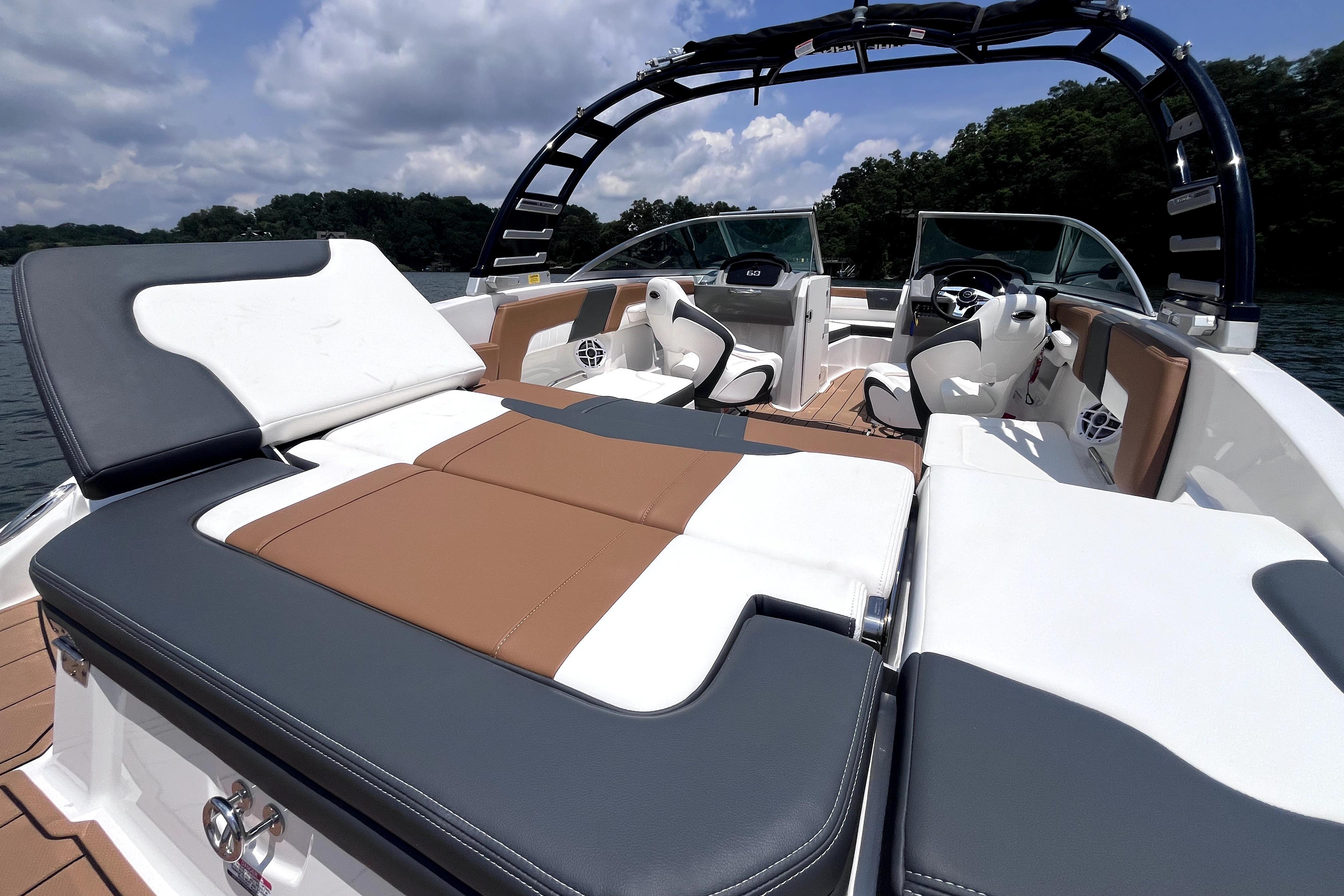 2025 Chaparral 230 SSi boat interior with luxurious seating and sleek design on a sunny day.