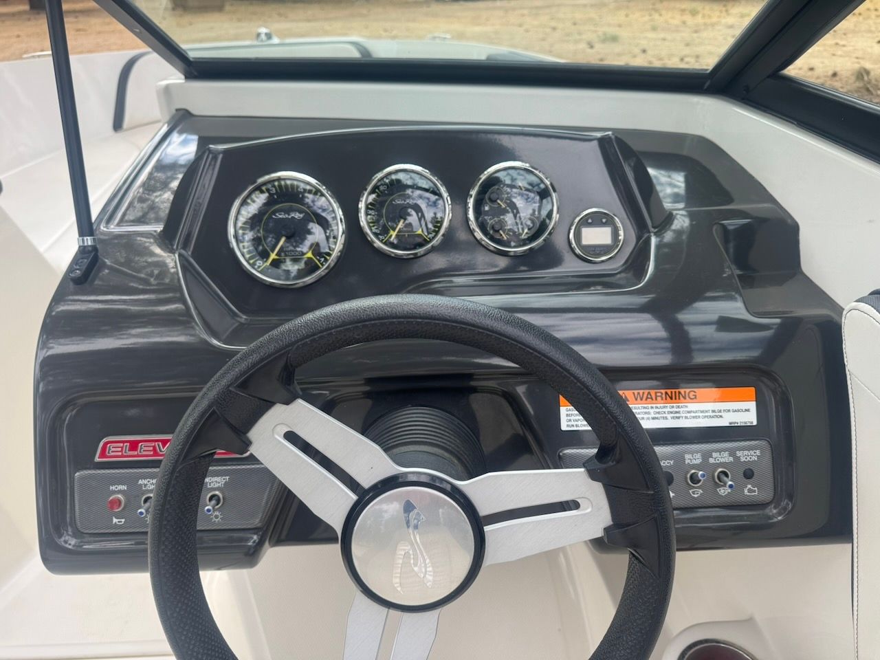 Dashboard of a 2016 Sea Ray SPX 190 Outboard with steering wheel and gauges.