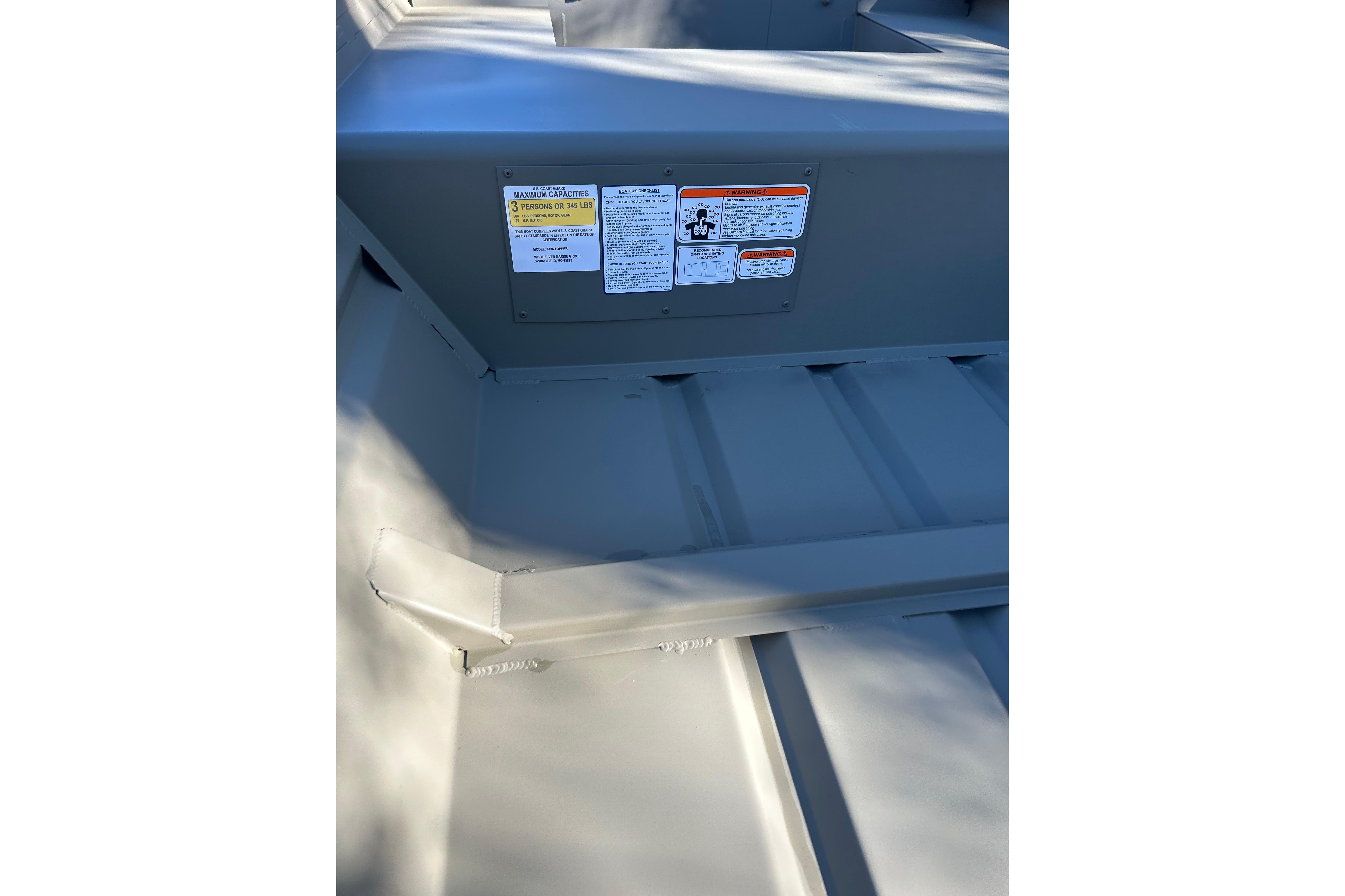 2026 Tracker Grizzly 14 Jon boat interior with safety labels visible.