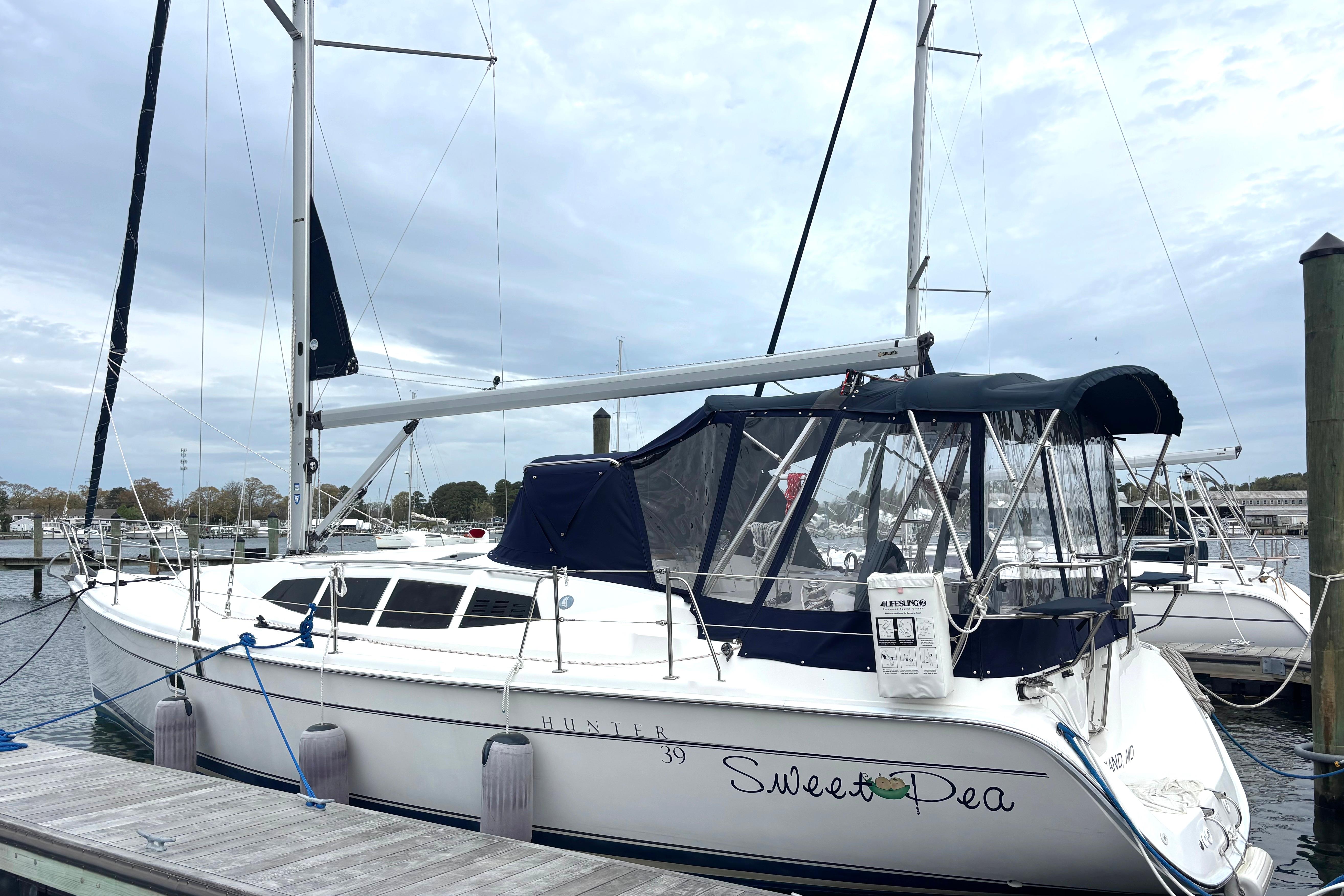 2011 Hunter 39 sailboat docked, featuring a sleek design and blue canopy.