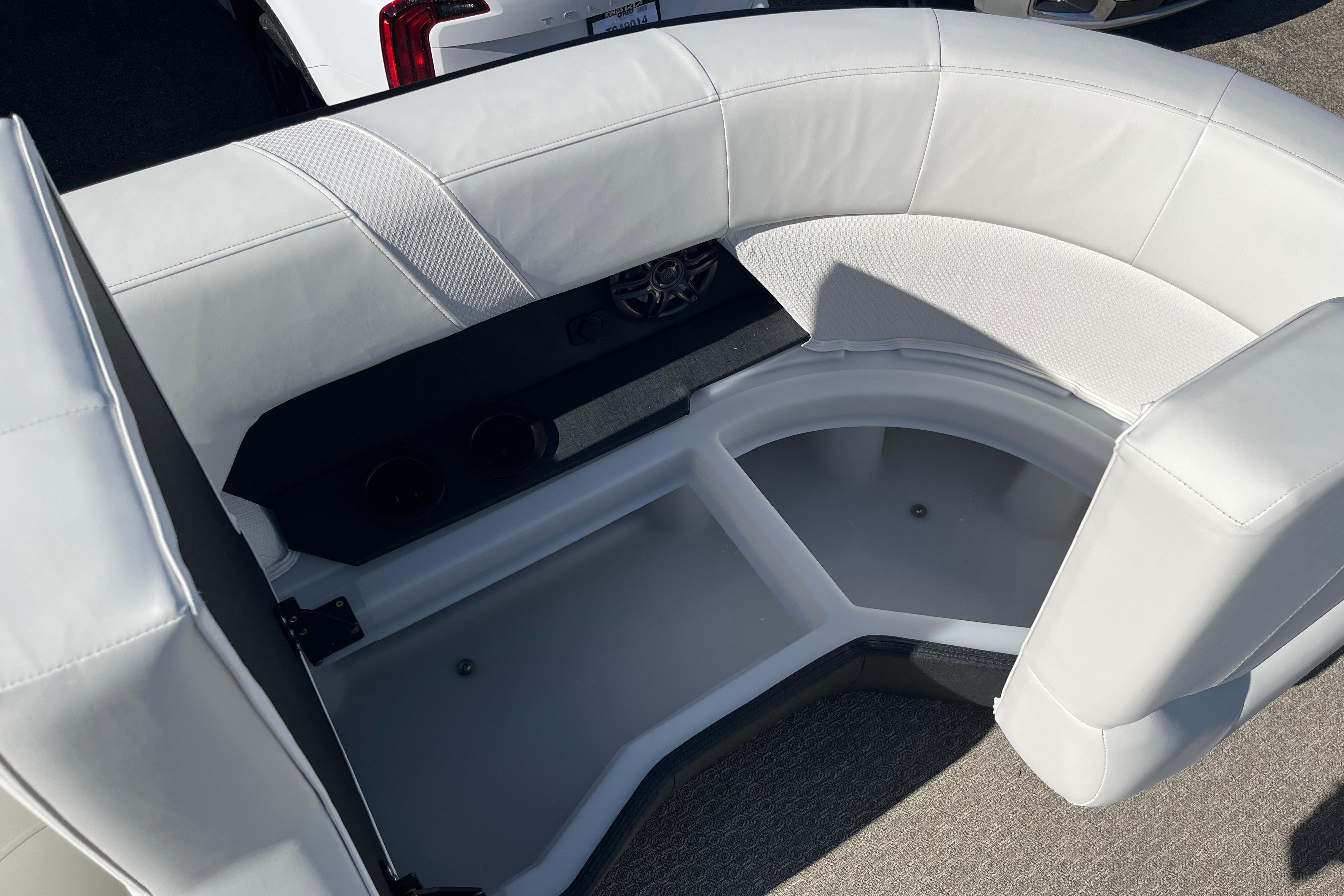Luxurious white seating in 2026 Evotti 523CS boat, featuring storage and cup holders.